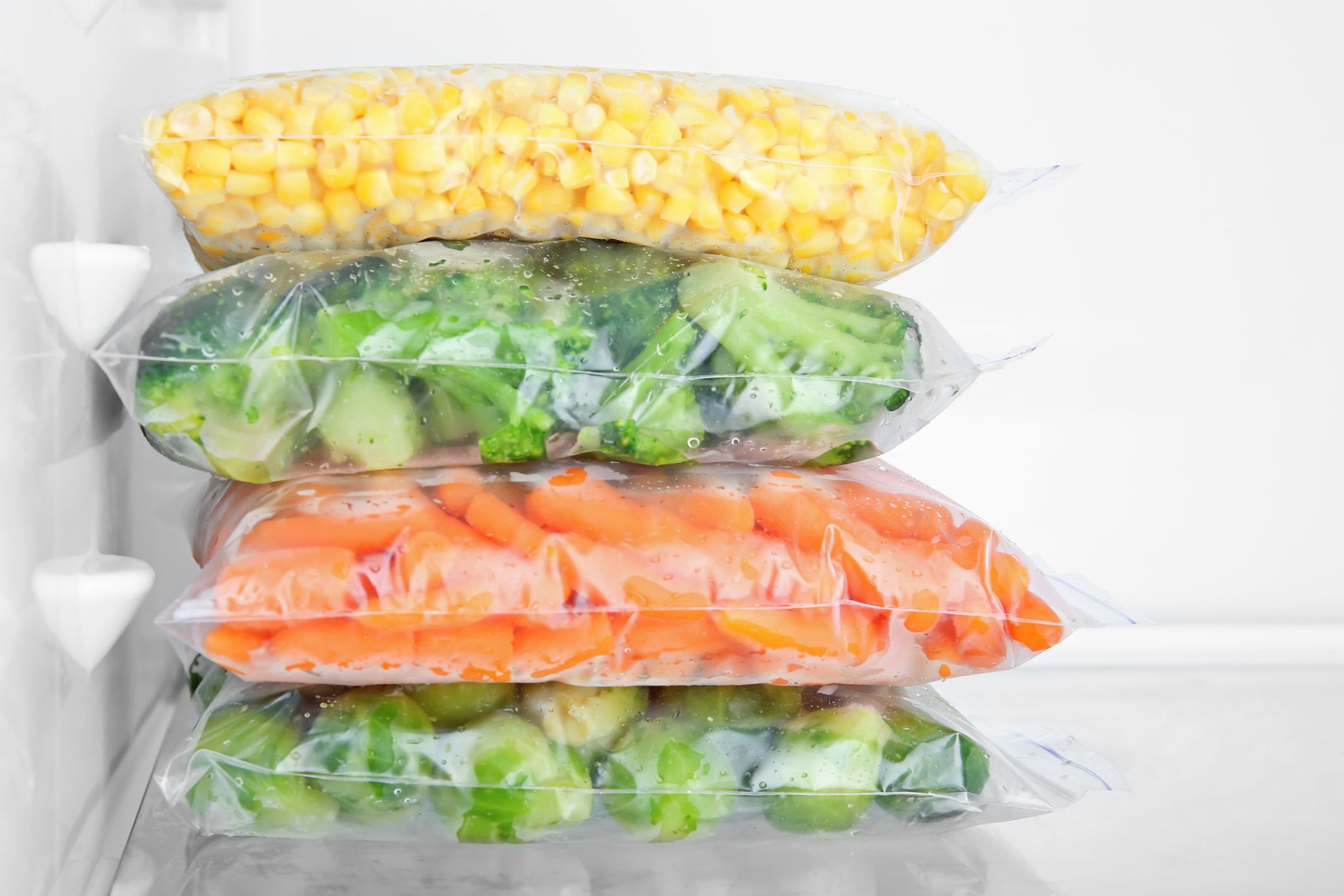 frozen vegetable bags stacked in freezer