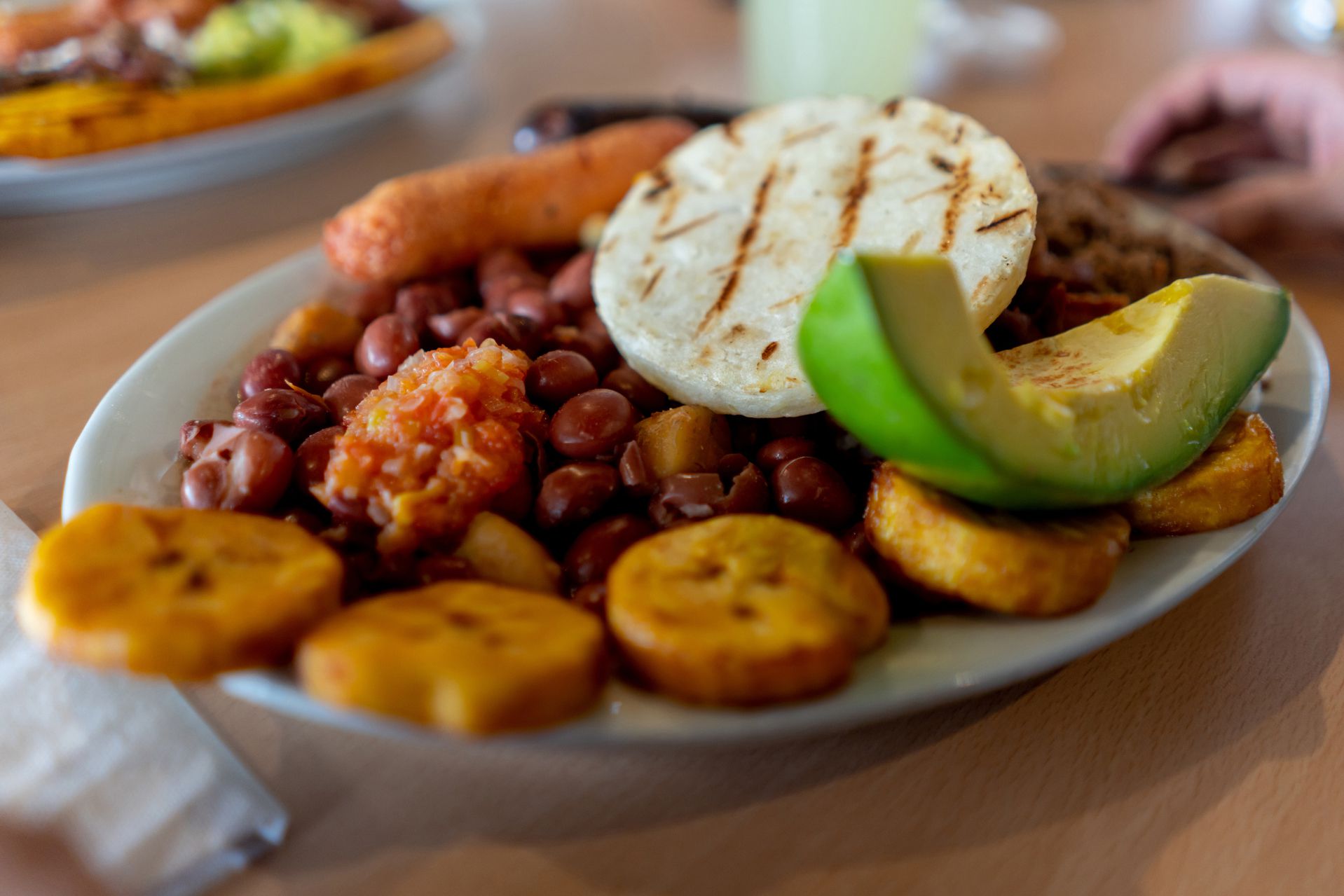 colombian lunch platter with plantains, beans, rice, avocado