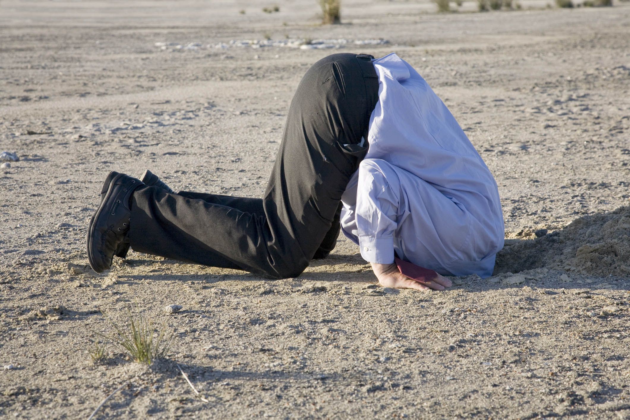 man with head in ground buried