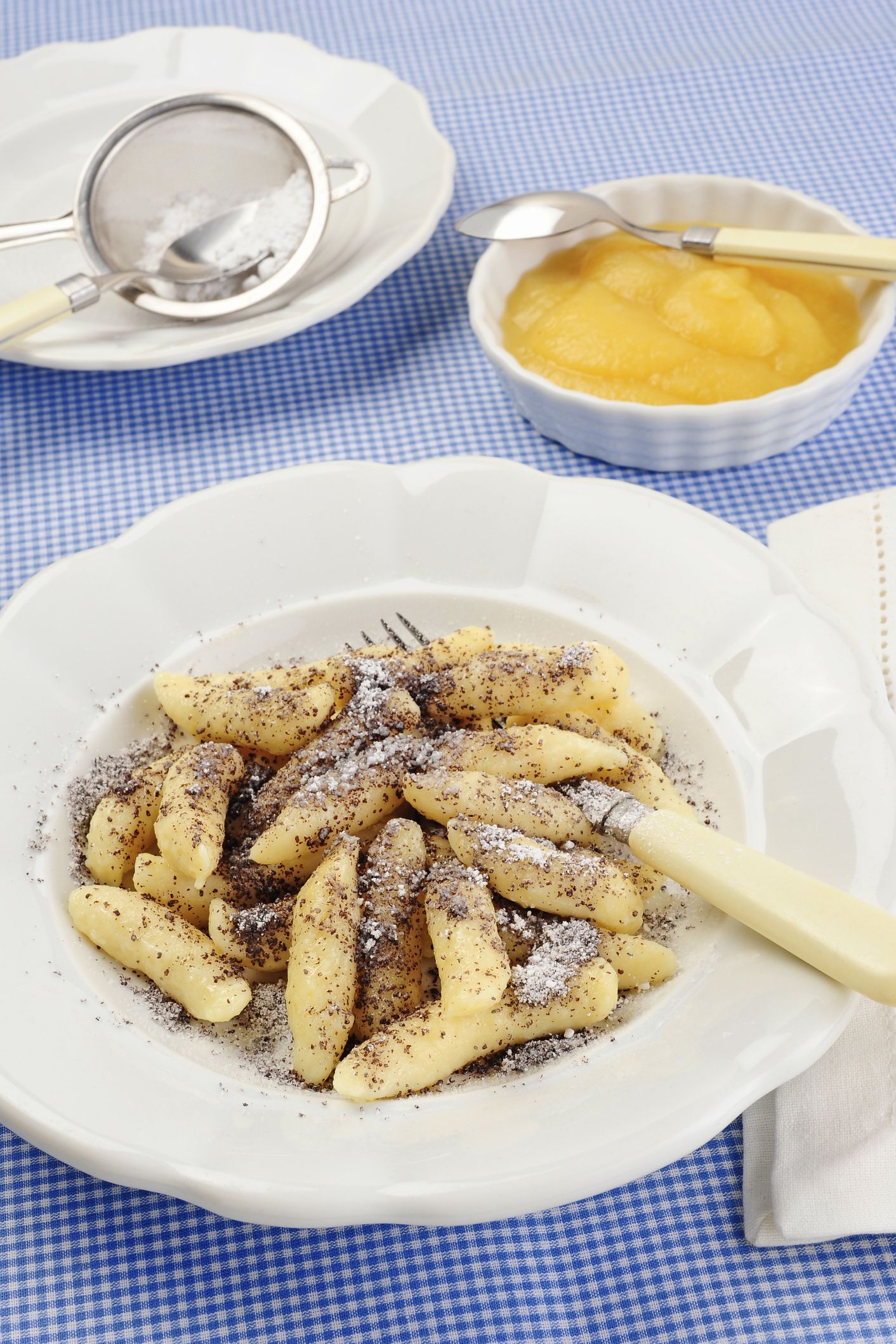noodles with poppy seeds, sugar and fruit soup in background