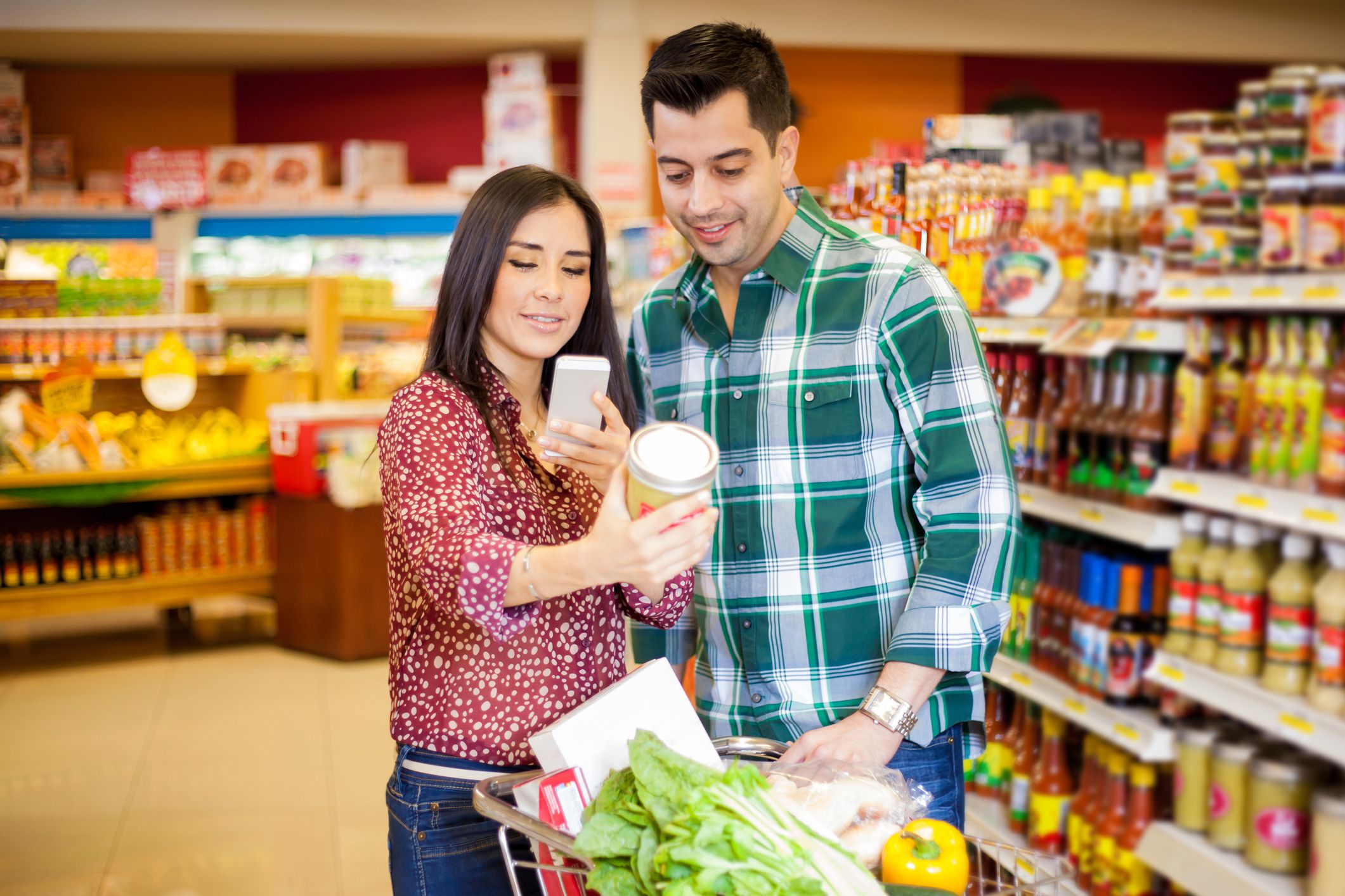 couple scanning supermarket item on smartphone