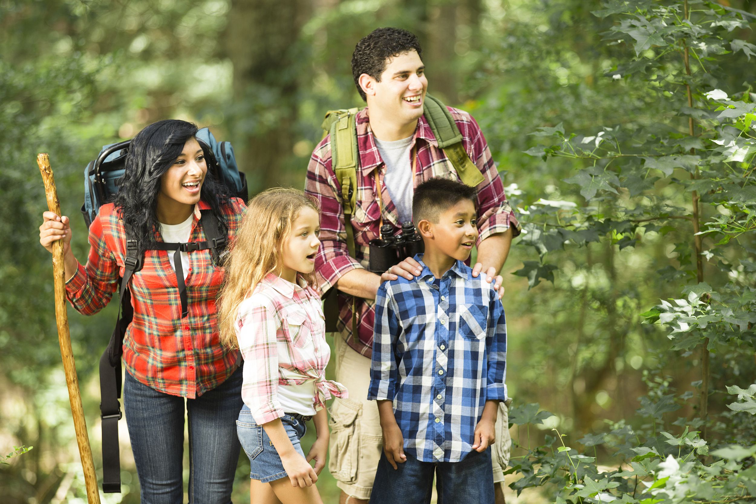 multi-ethnic family hiking, backpacking outdoors in national park area