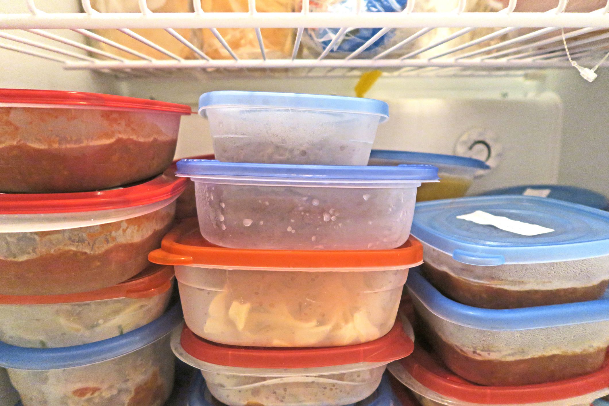 leftovers from various meals stacked in fridge