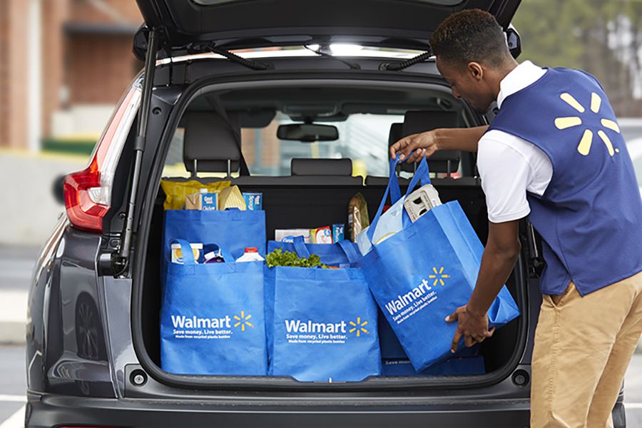 walmart staff member putting groceries in back of car