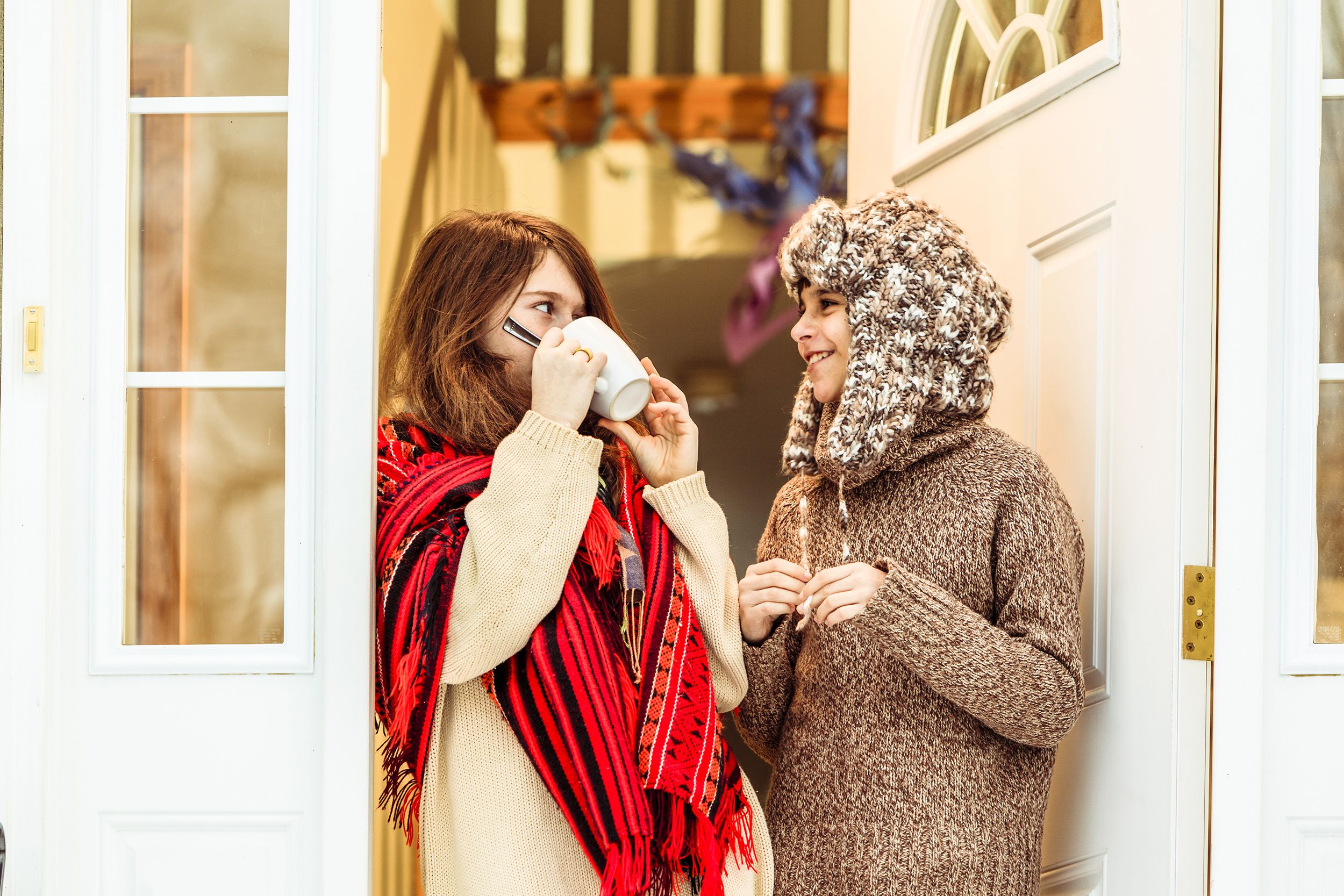 two young sisters, before country house in winter