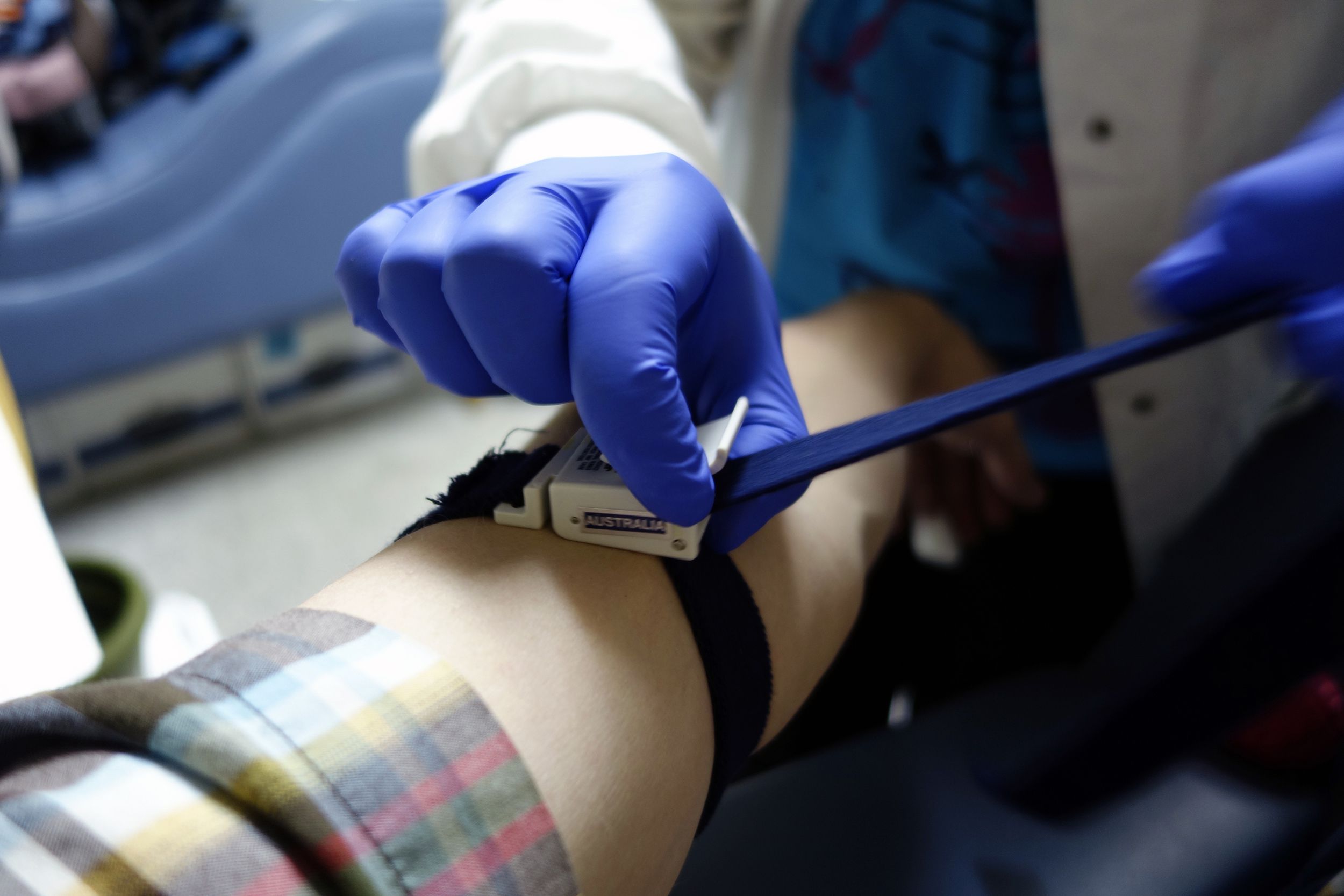 person affixing a tourniquet to bleeding patient