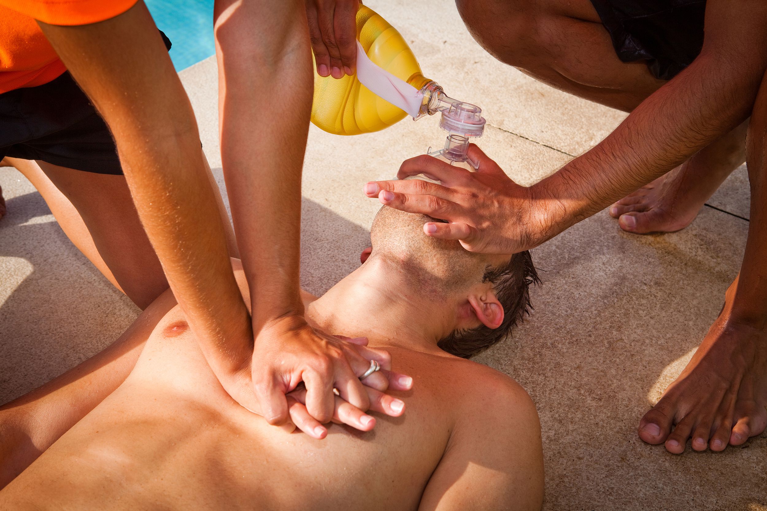 two lifeguards giving CPR to a drowned man