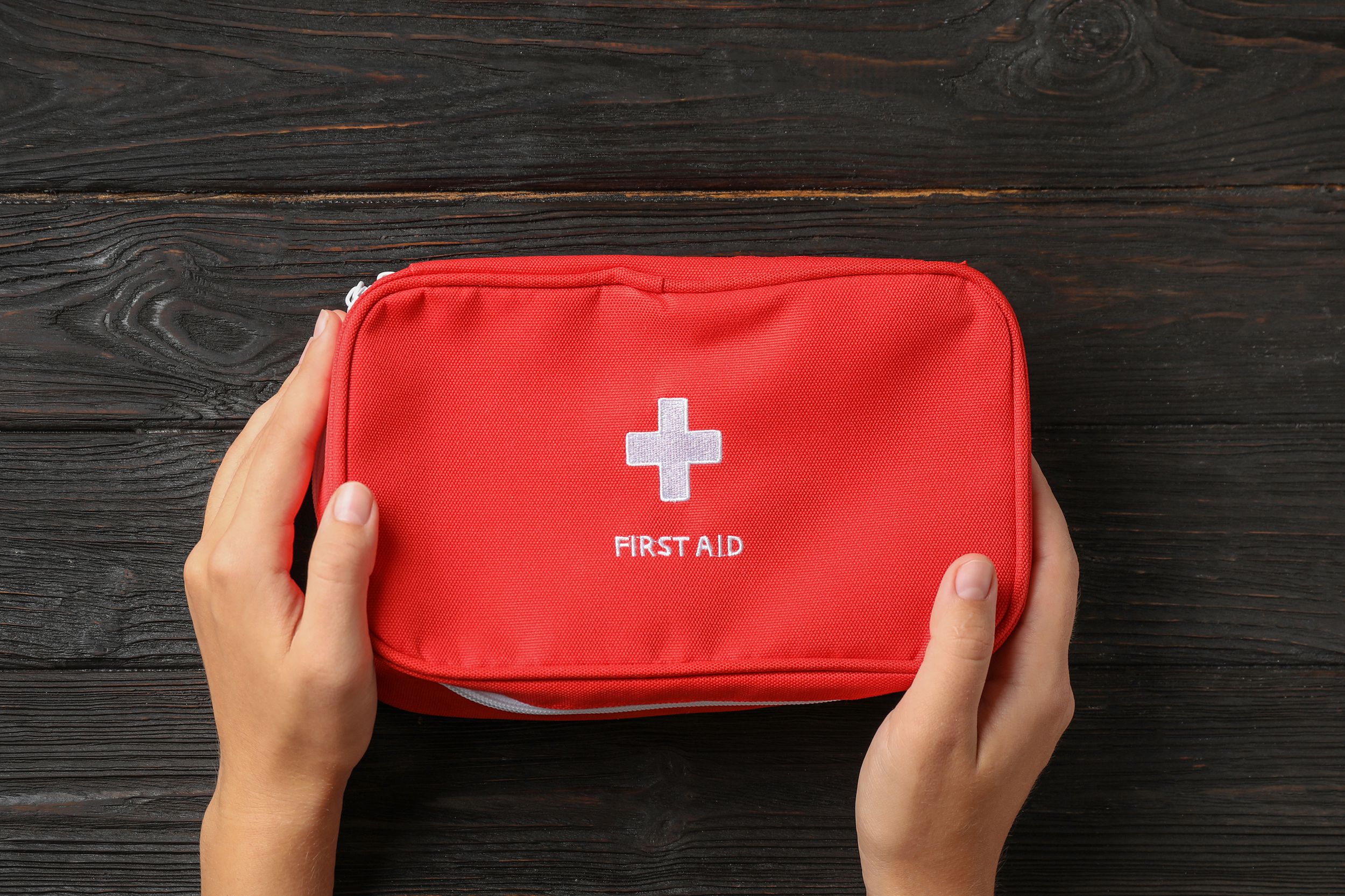 woman holding first aid kit on dark table