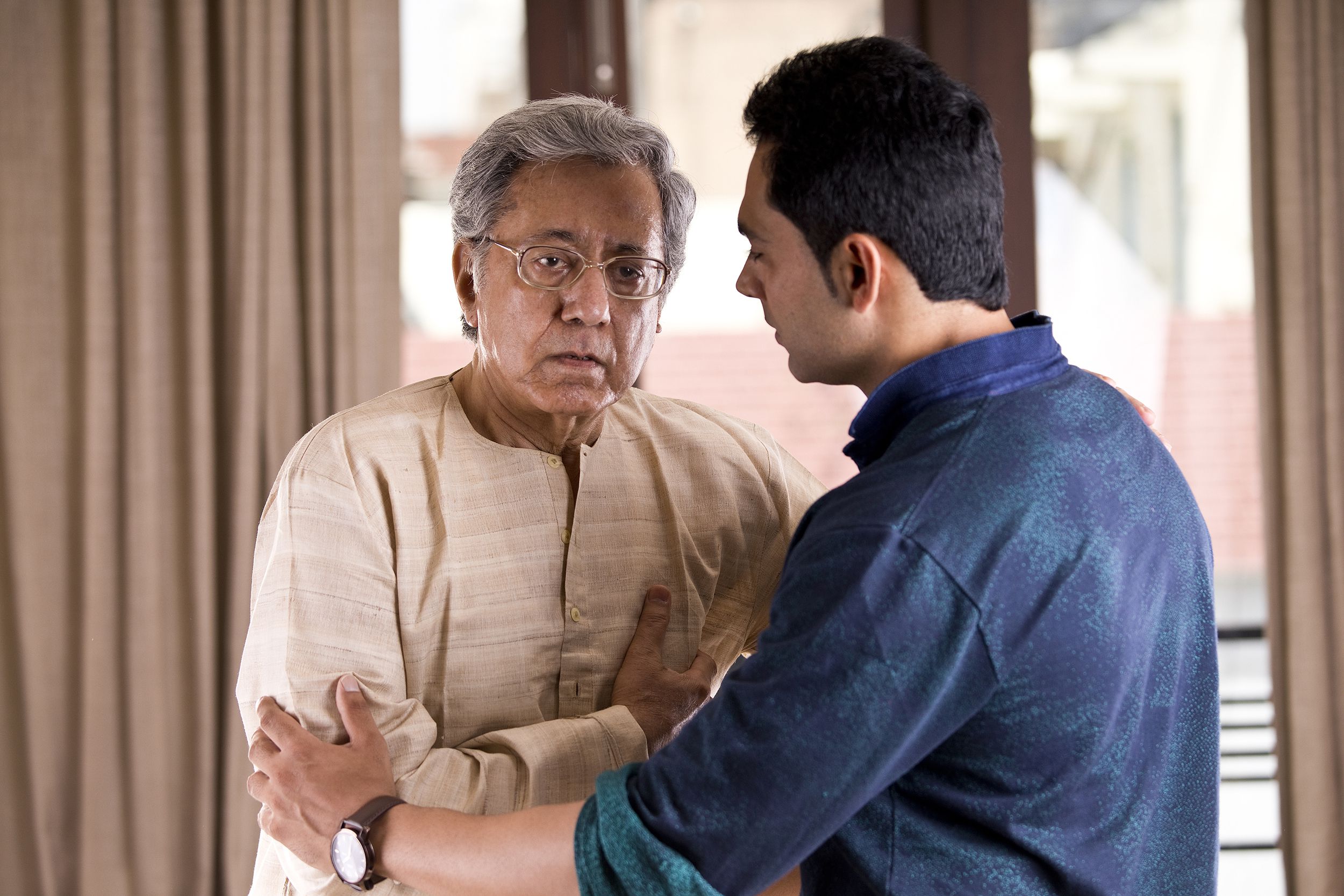 son helping father having chest pain at home