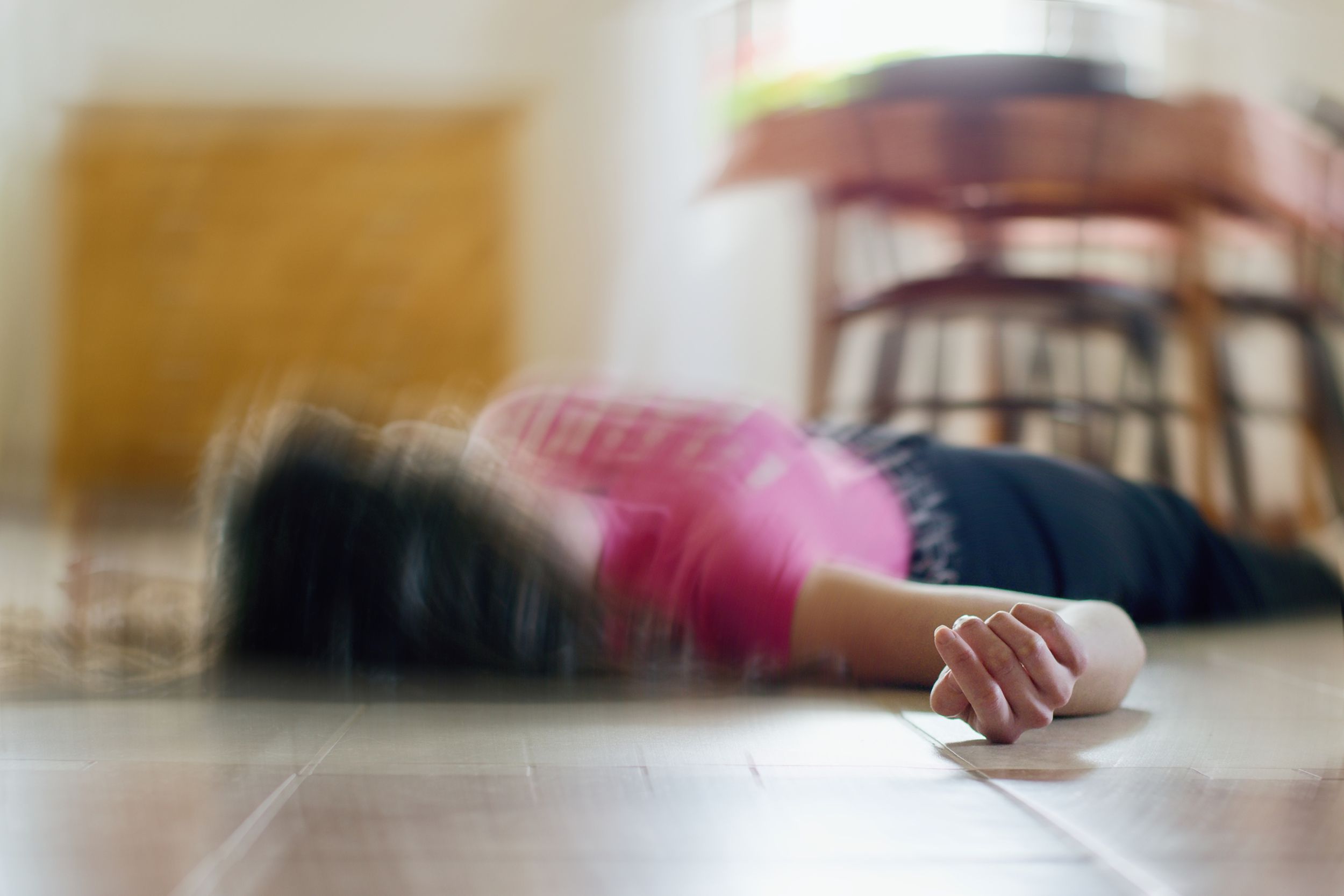 woman lying on the floor at home having a seizure