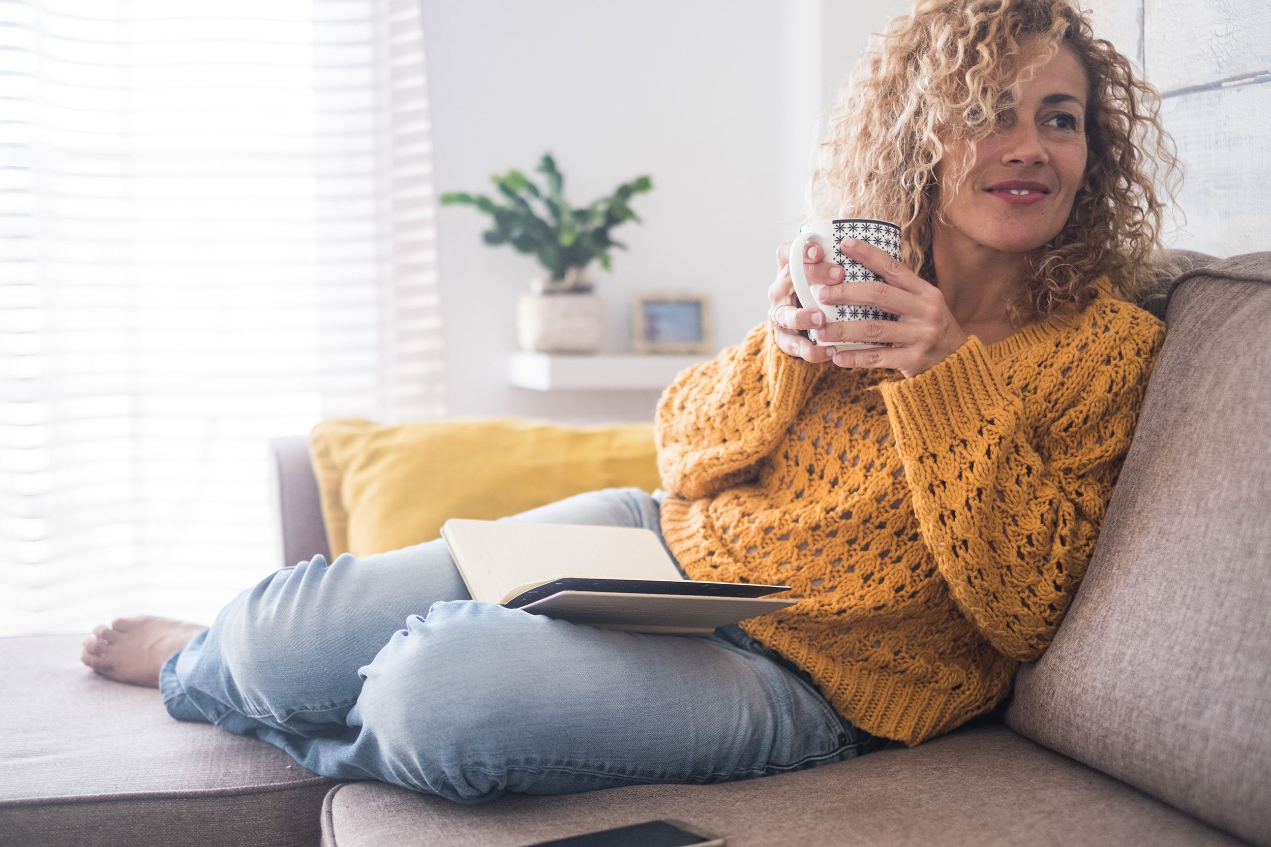 middle-aged woman sitting at home, reading book
