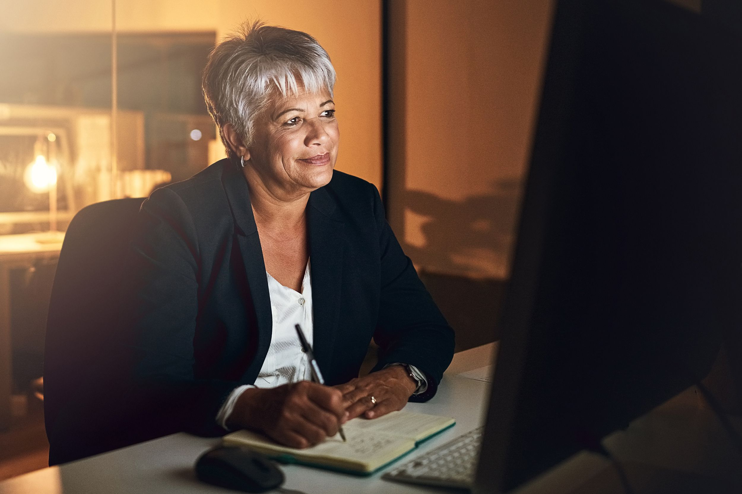middle-aged woman working late at night at the office