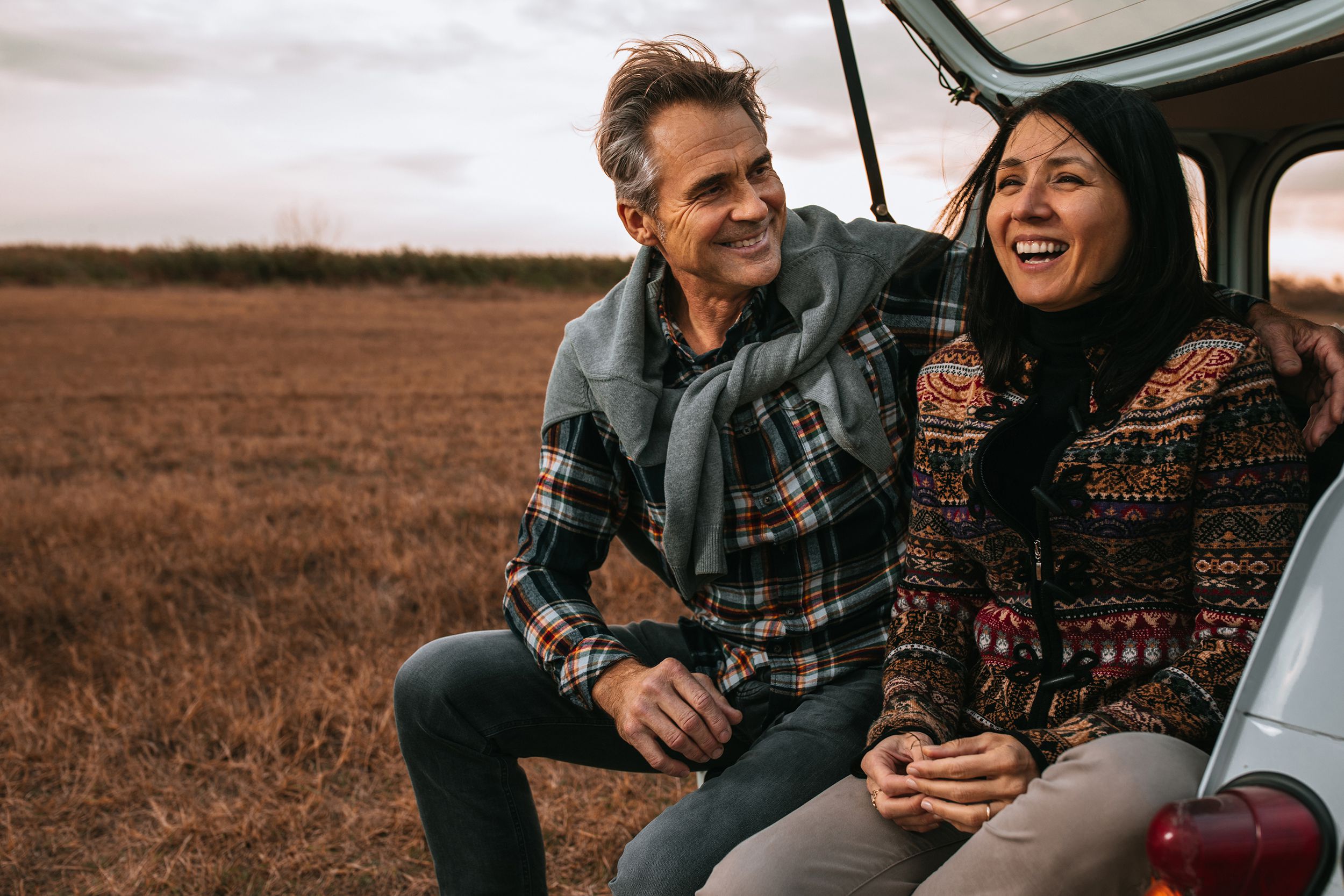 middle-aged couple hugging while outside during fall