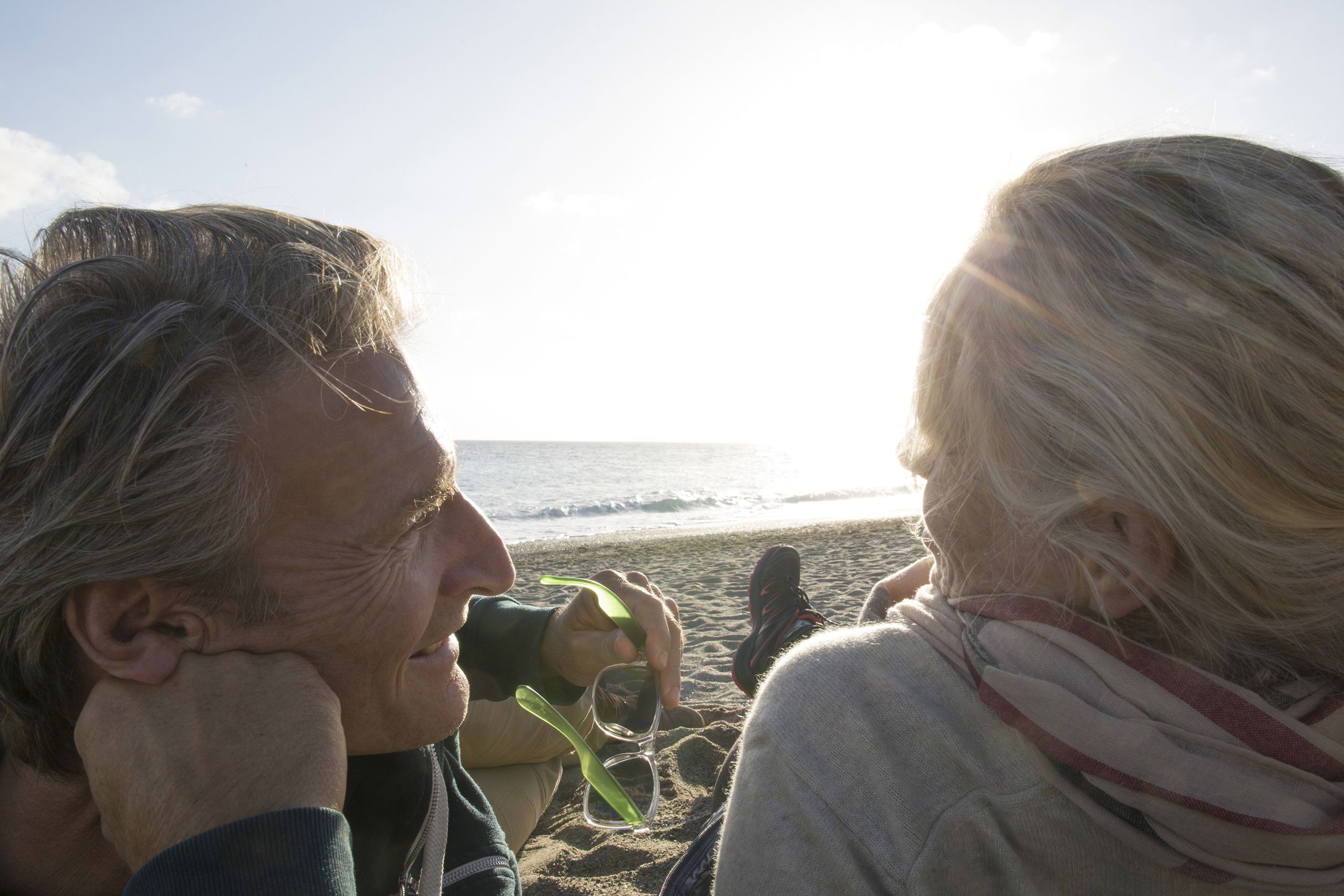 couple relax on beach in sunlight