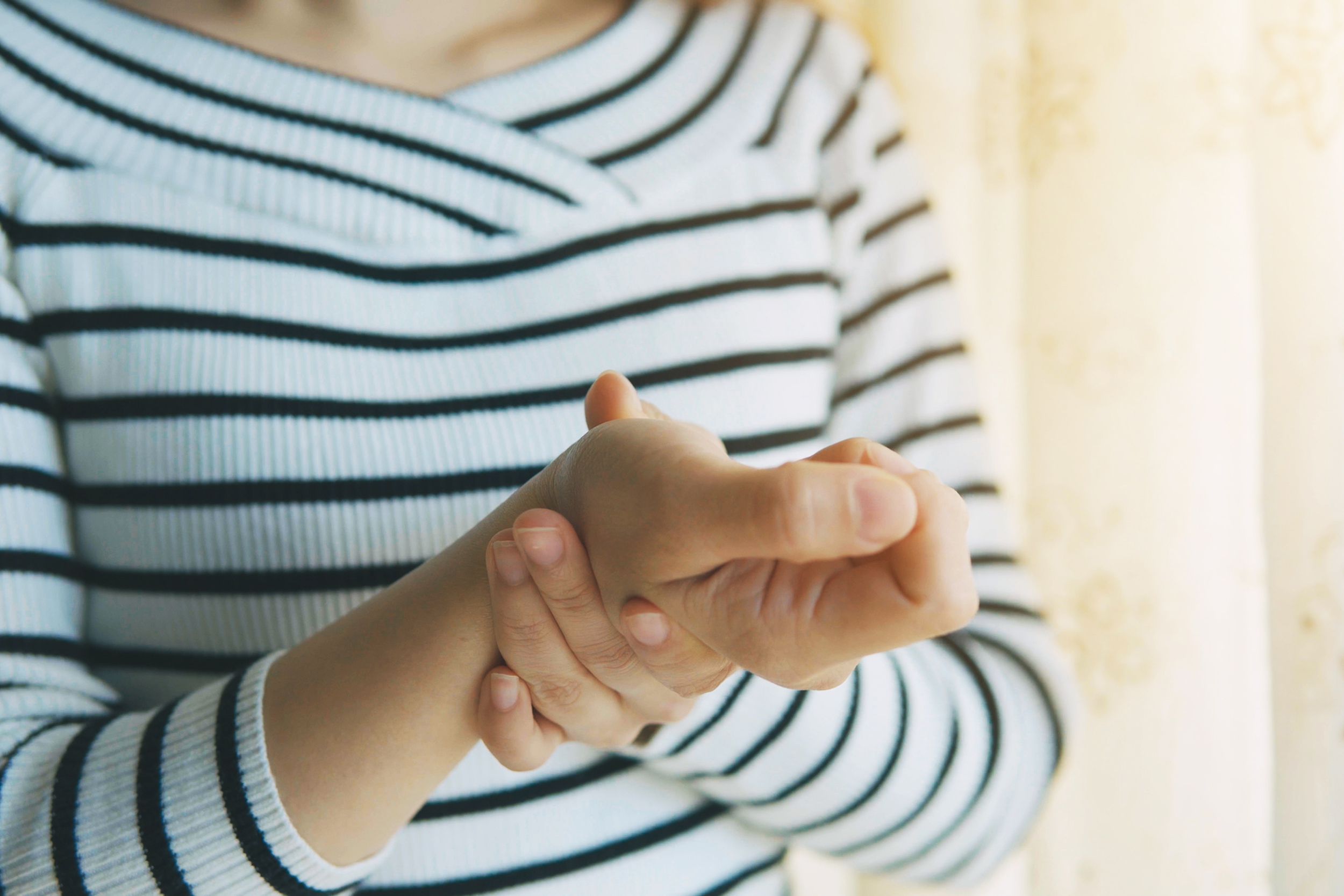 woman massaging her arthritic hand and wrist