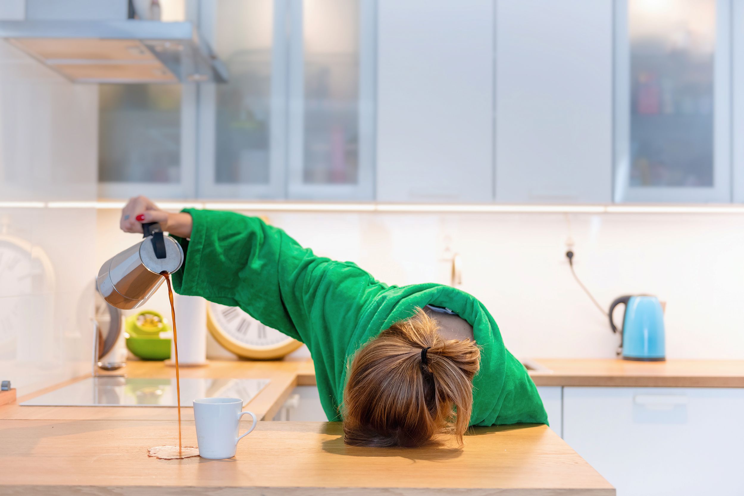 tired woman sleeping on the table in the kitchen at breakfast