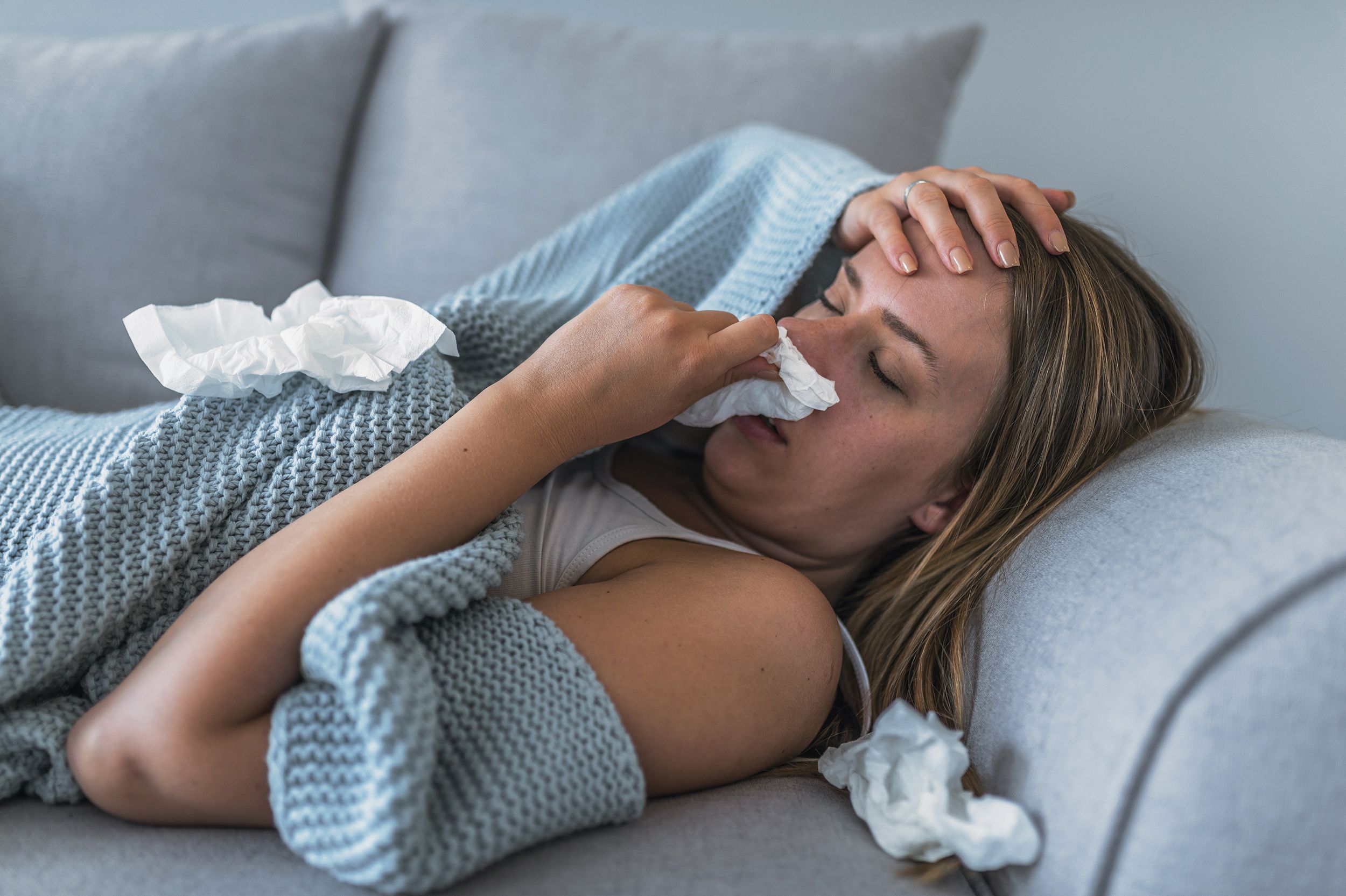 sick woman laying on couch