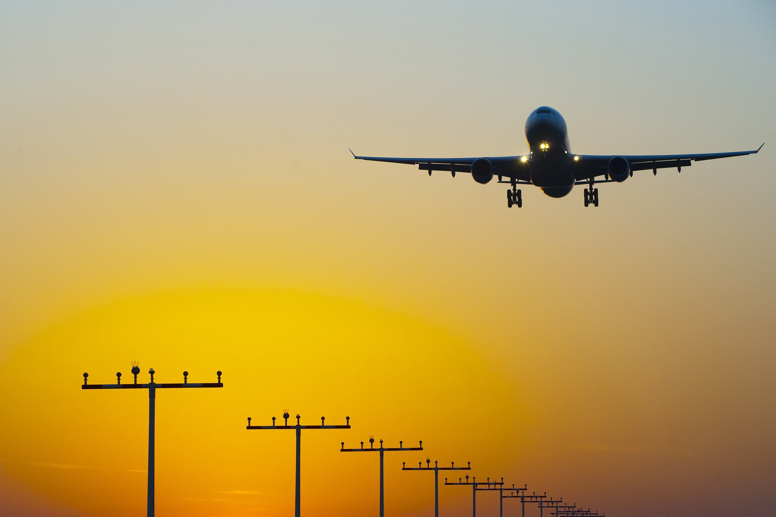 landing jet at airport during sunrise