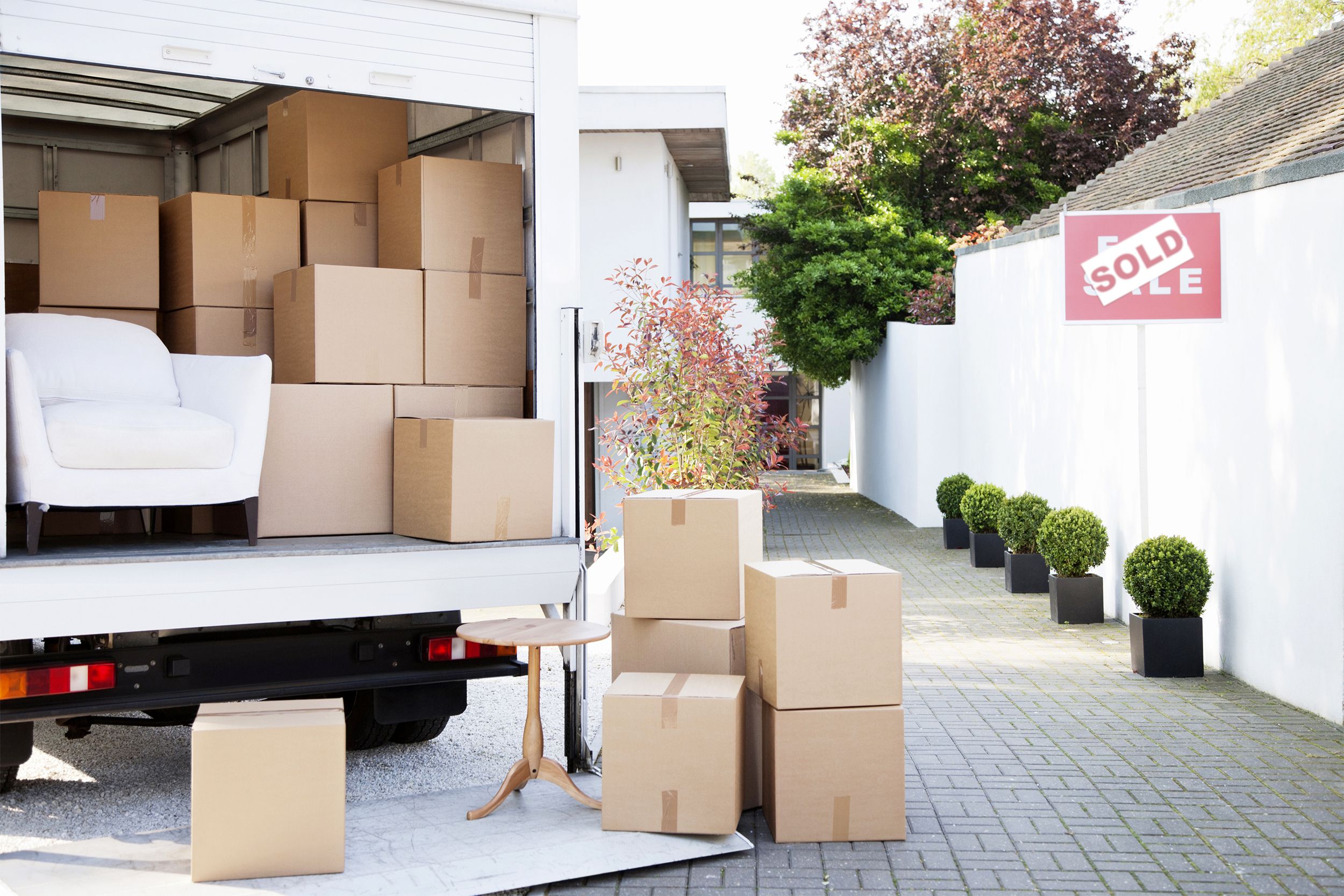Moving boxes in a truck outside of sold house