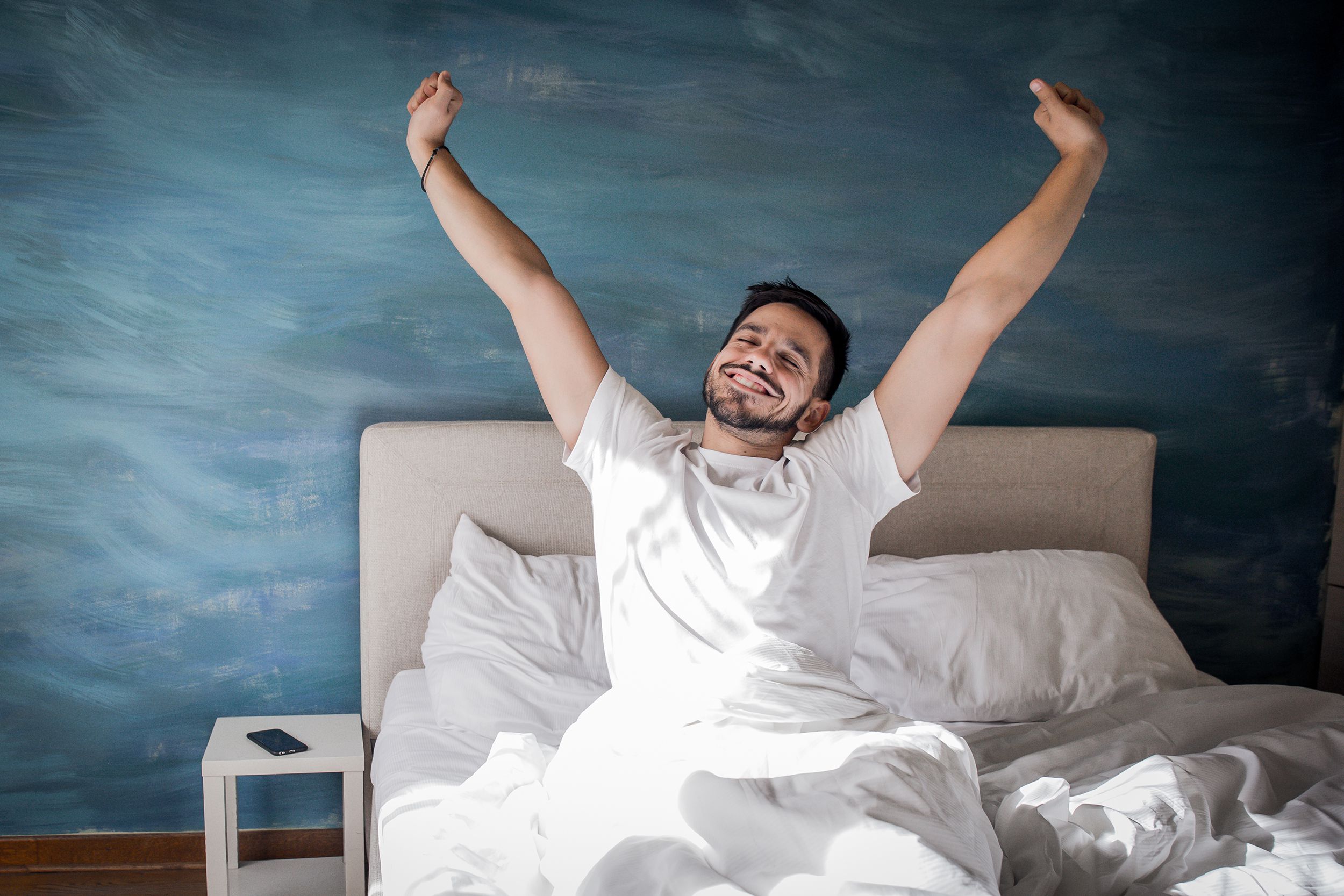 happy man waking up in bed