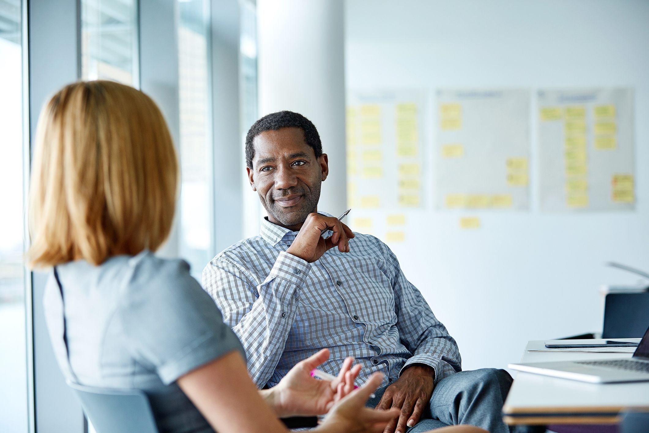 two coworkers talking smiling and discussing