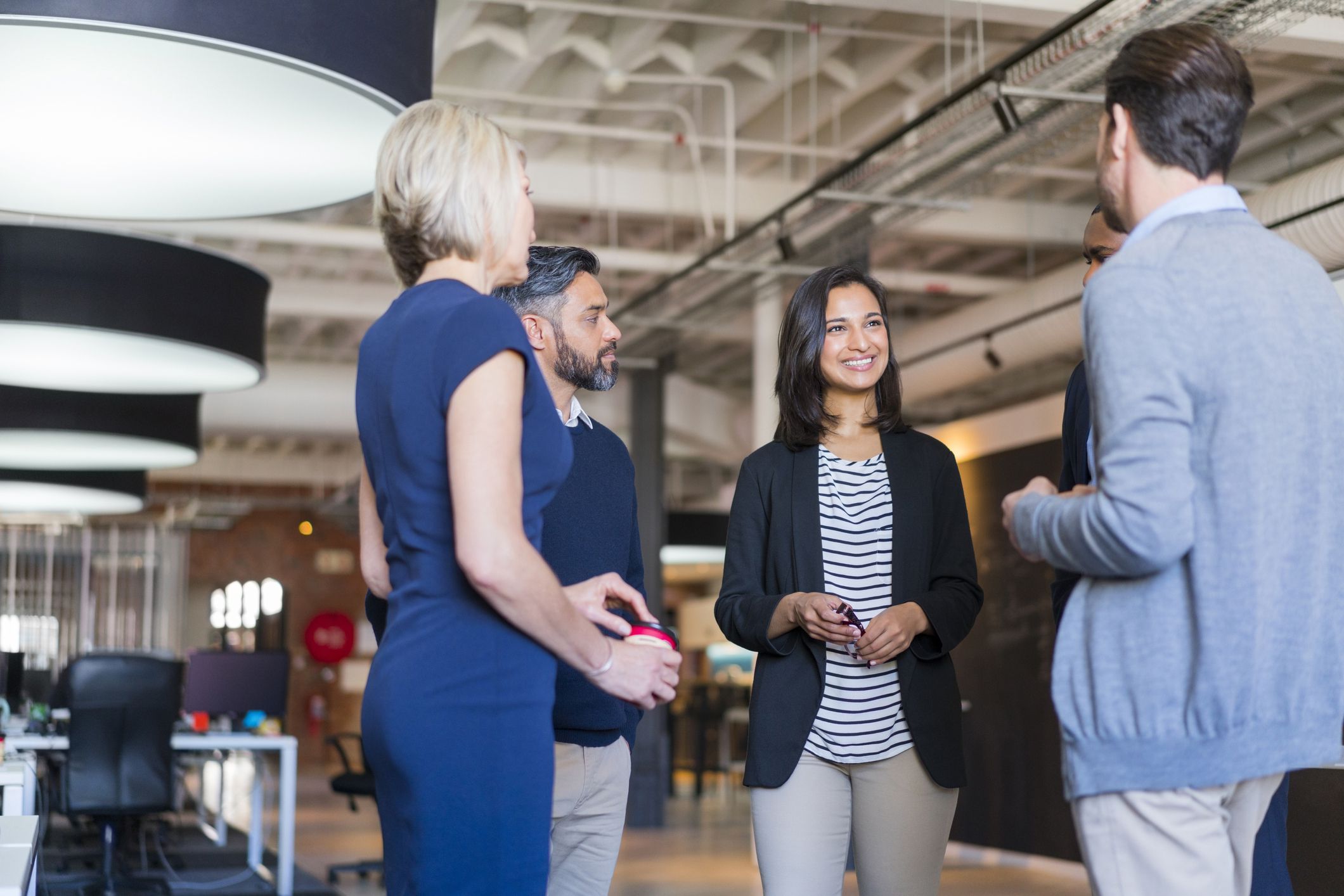 four people smiling and talking at a networking event