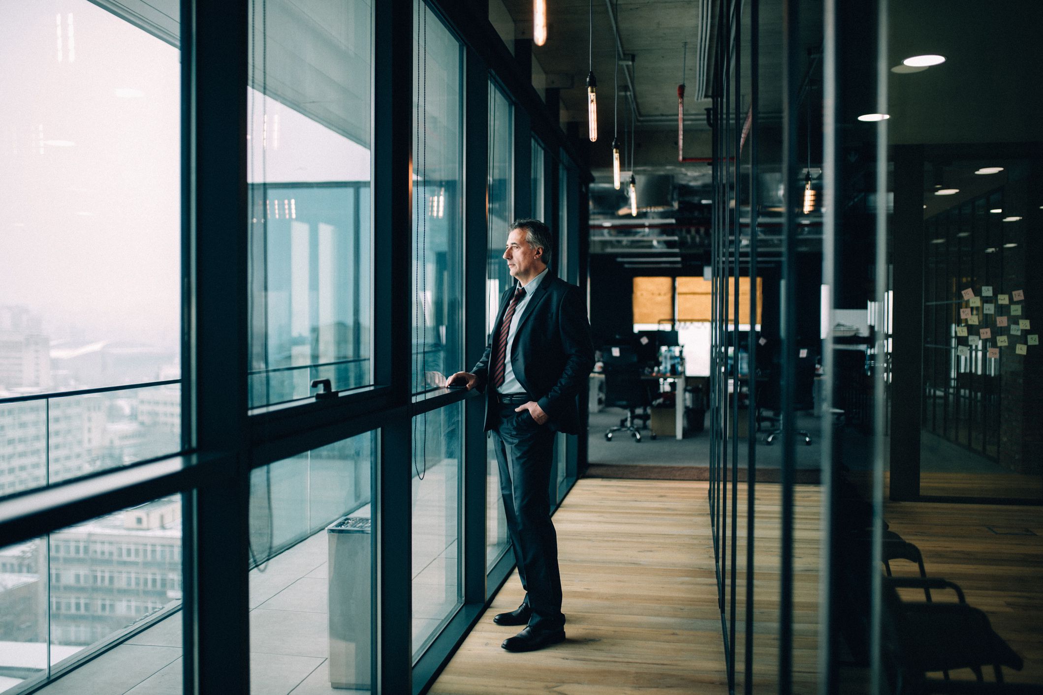 businessman looking out window stoically