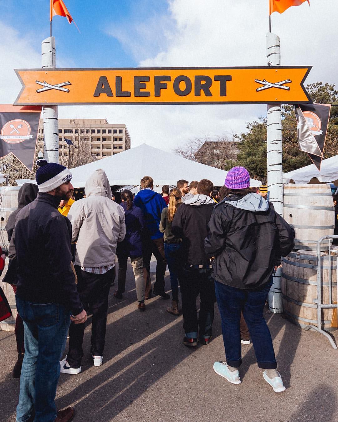 people walking under alefort beer festival entry arch