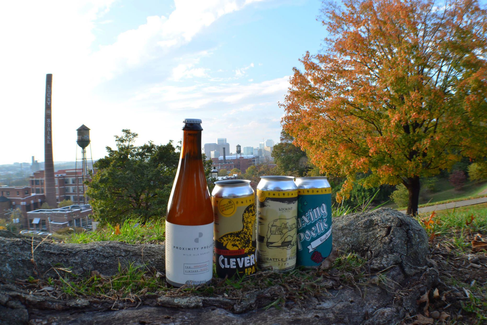 triple crossing beer cans and bottle with Richmond skyline in background