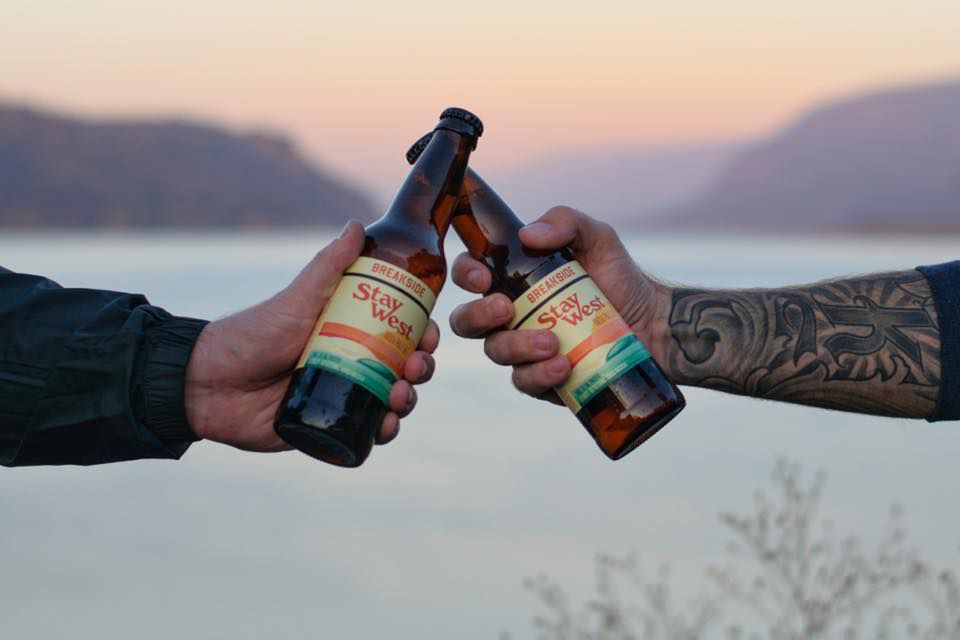 clinking bottle of broadside brewery beer