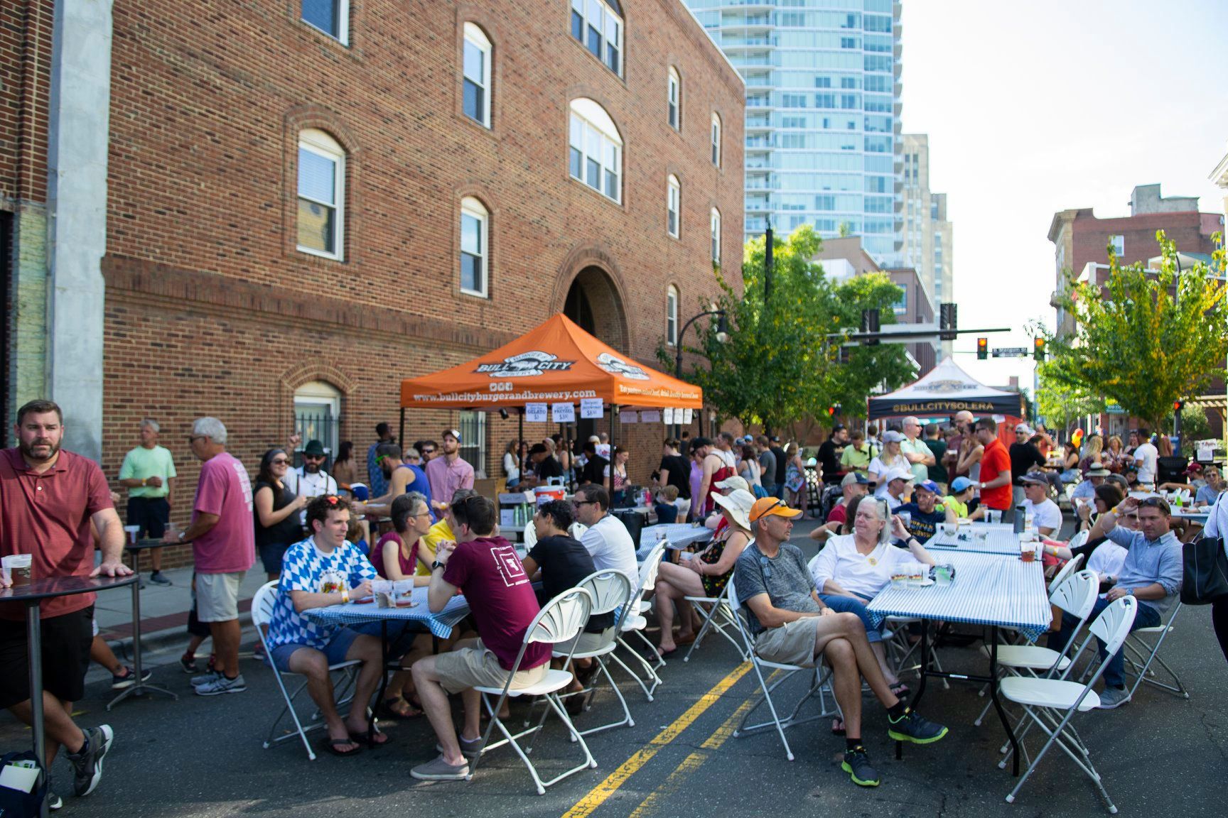 diners drinking beer on tables on street at octobullfest 2019