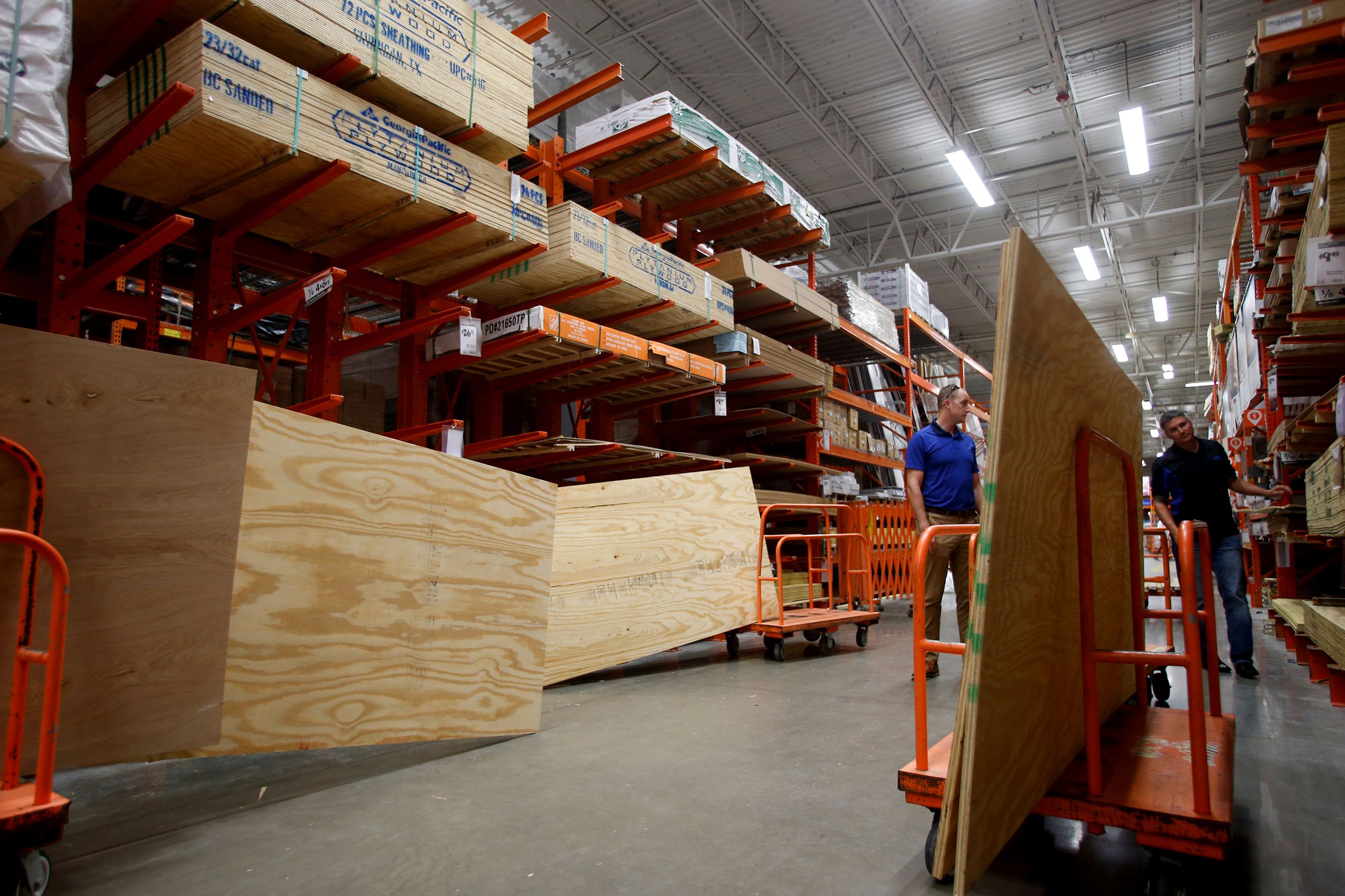 Shoppers gather plywood for makeshift storm shutters at a Home Depot store.