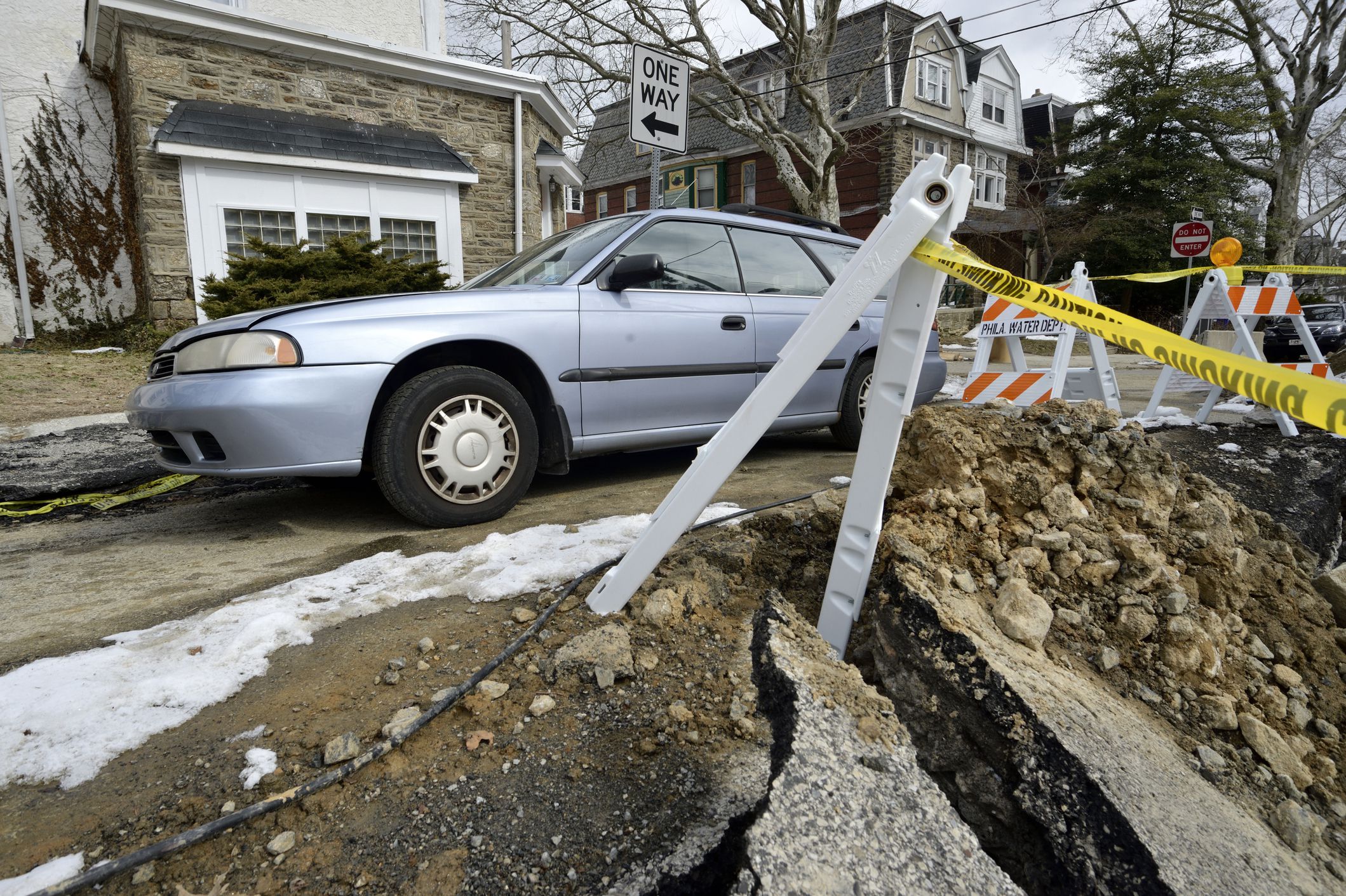 car passing a collapsed section of road in philadelphia