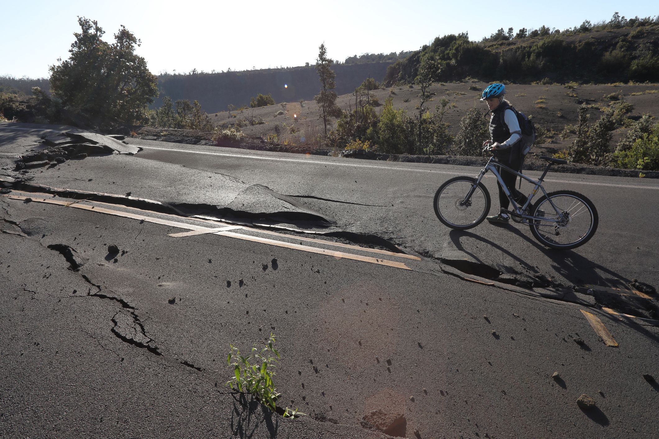 bicyclist stares at broken road