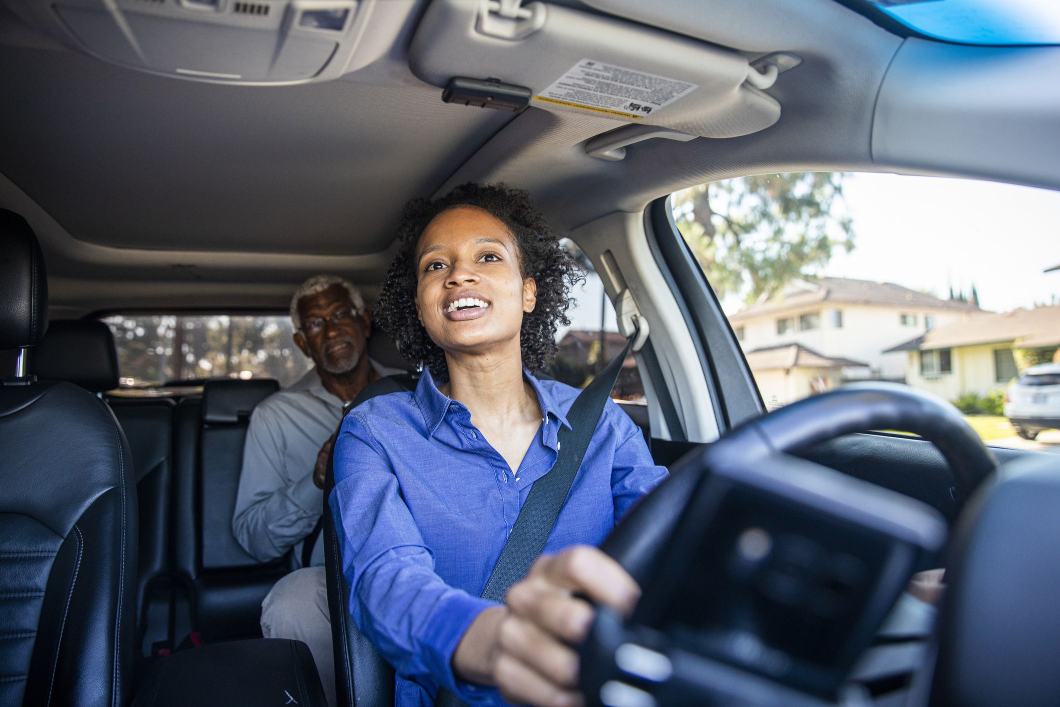 ride share driver looking at passenger in backseat through rearview mirror