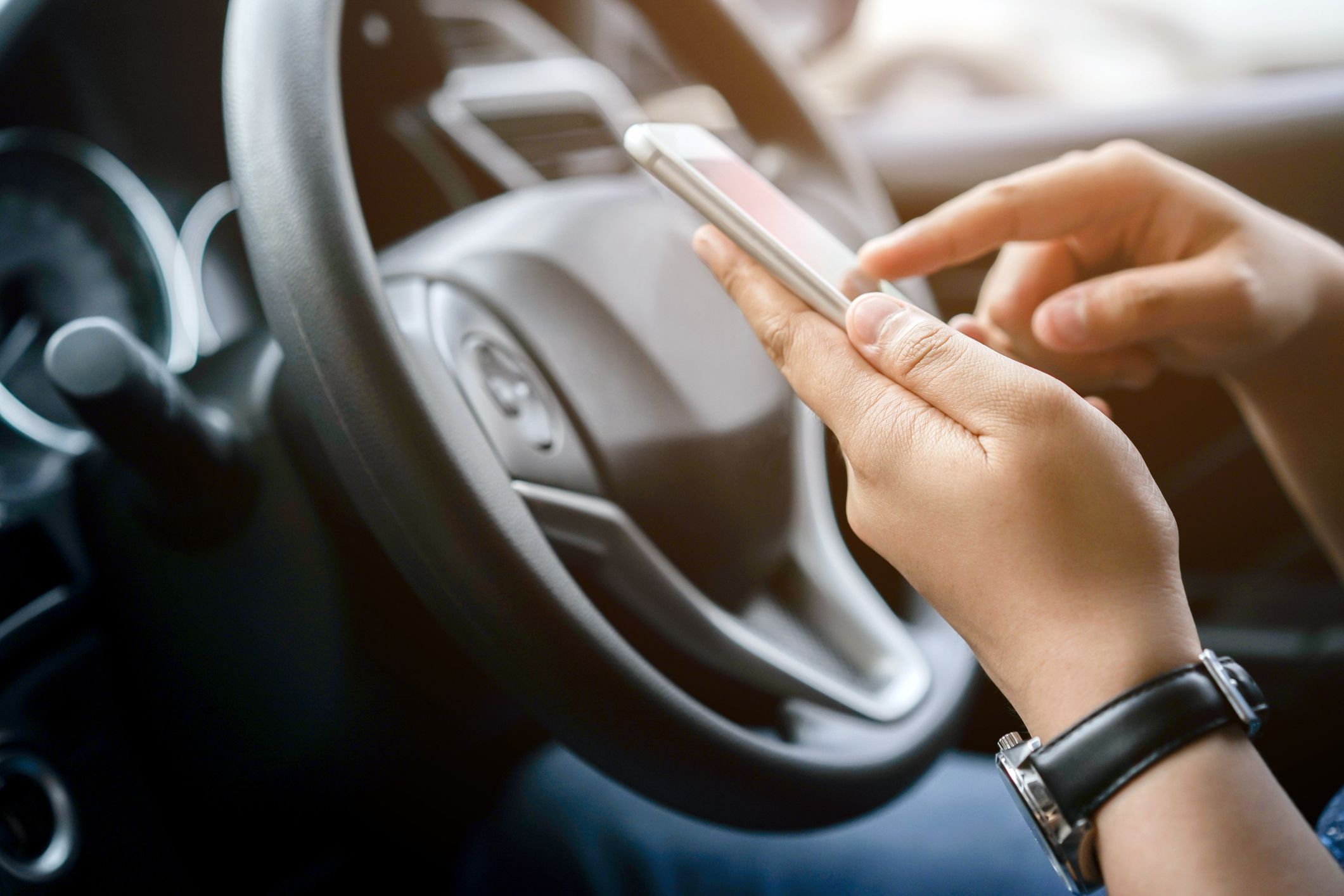 driver with hands holding phone