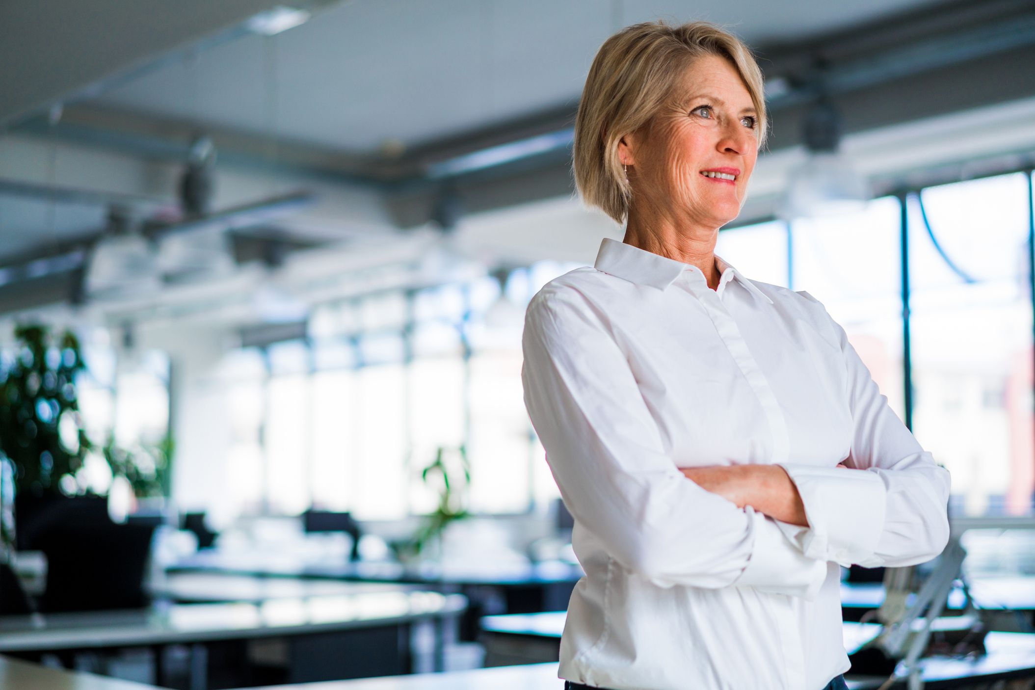 happy businesswoman looking out window