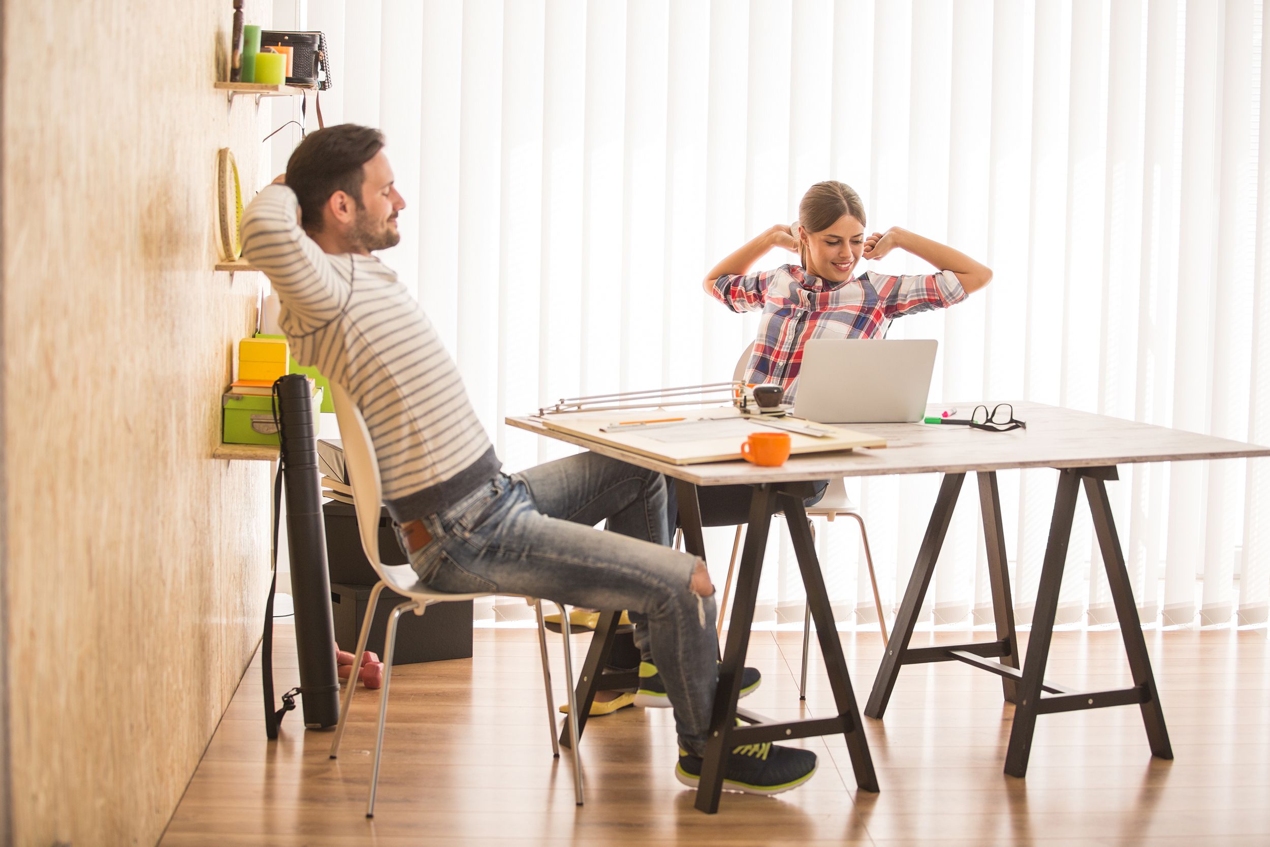 Young man and woman working at modern office doing glute squeezes