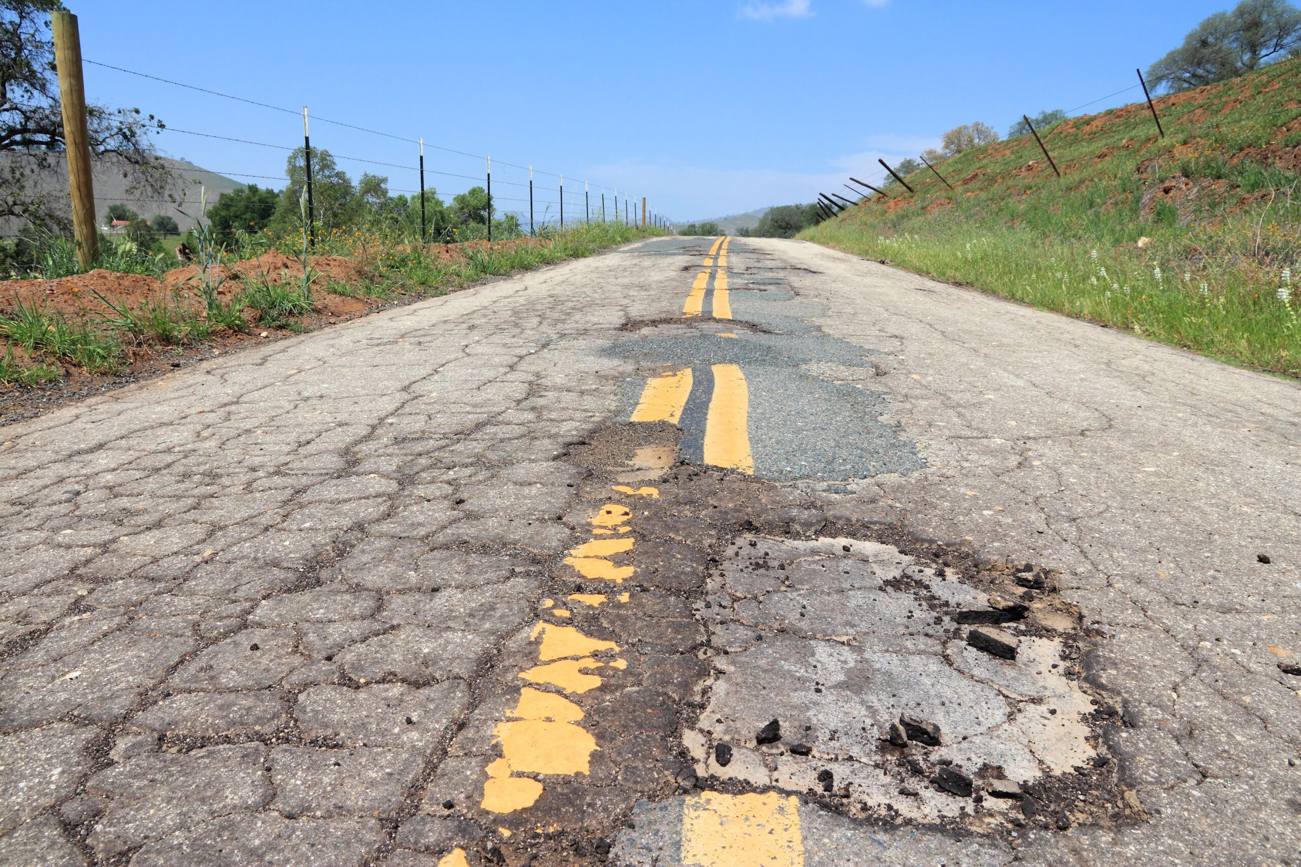 california road with potholes and cracks
