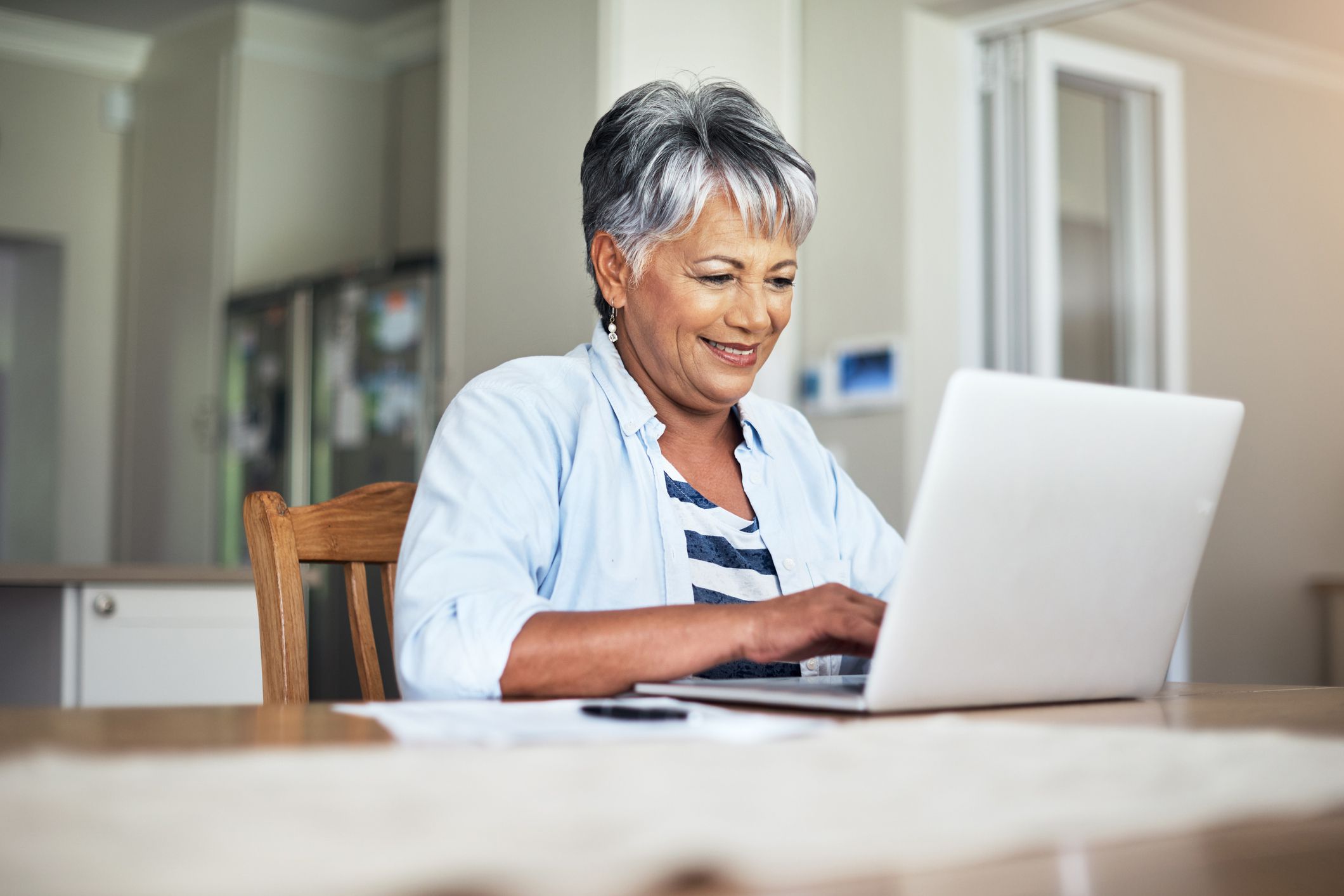 senior woman smiling looking at laptop