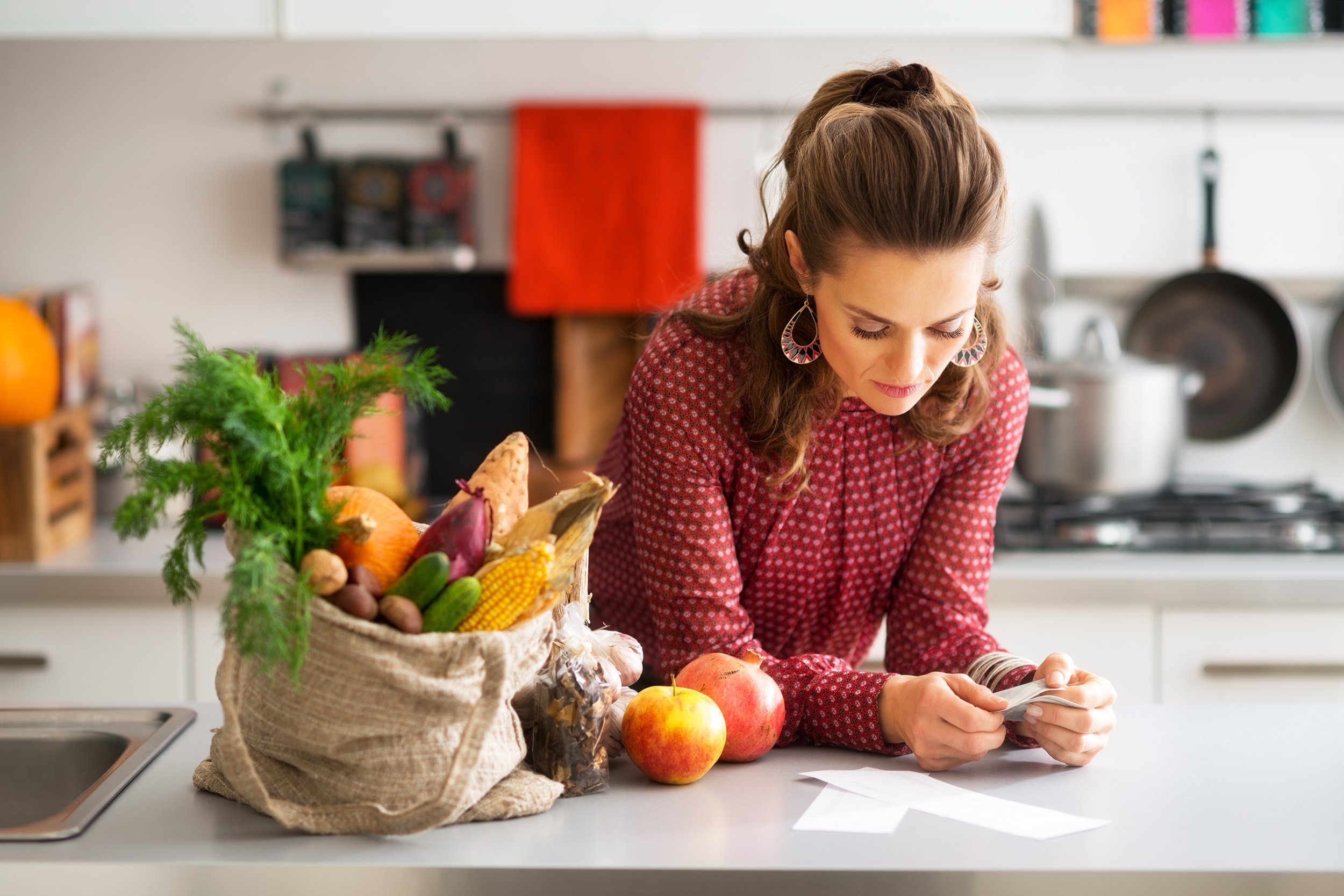 woman is reading the shopping lists on her kitchen counter
