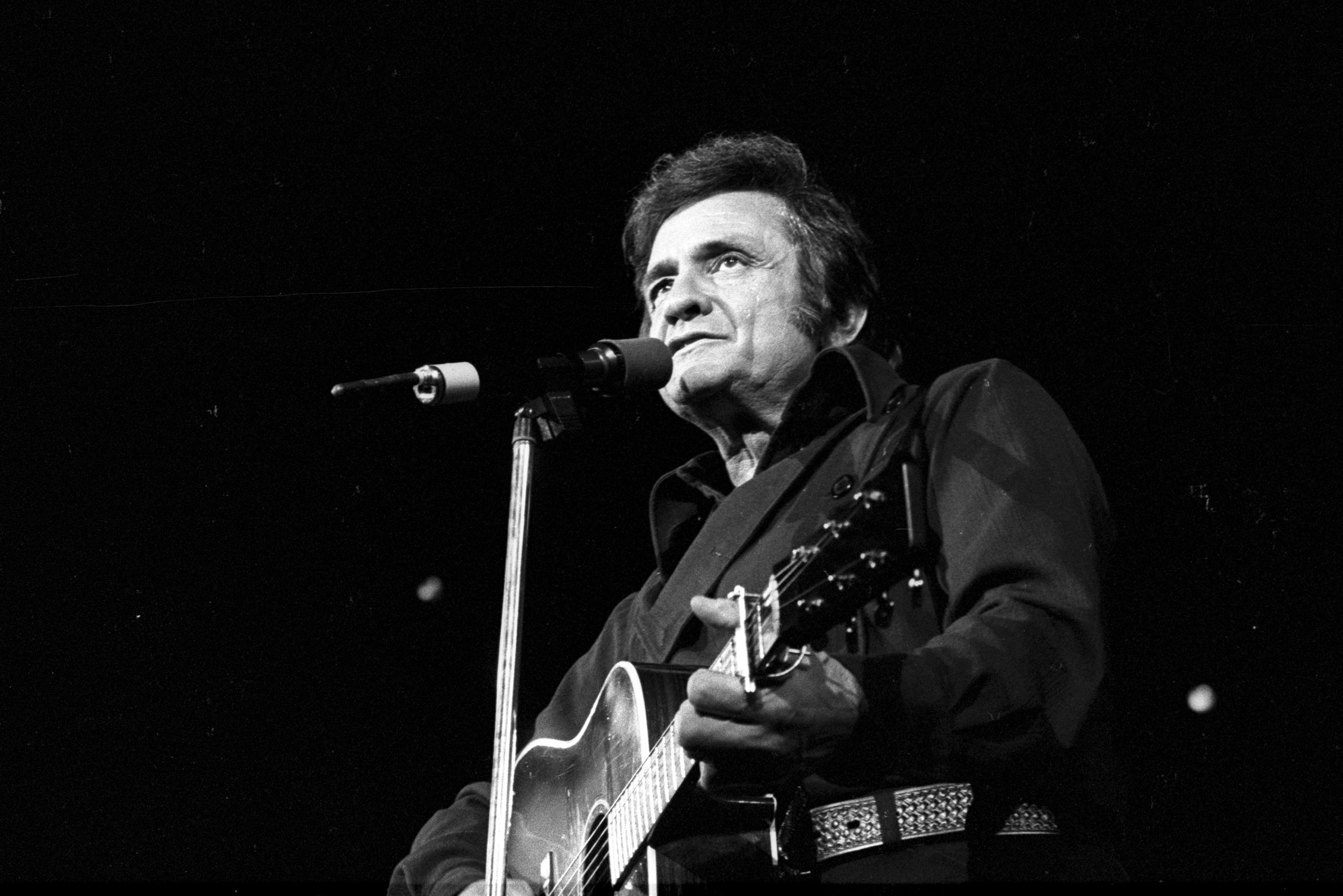 Country singer/songwriter Johnny Cash plays acoustic guitar as he performs onstage at the Anaheim Convention Center on March 11, 1978 in Anaheim, California.