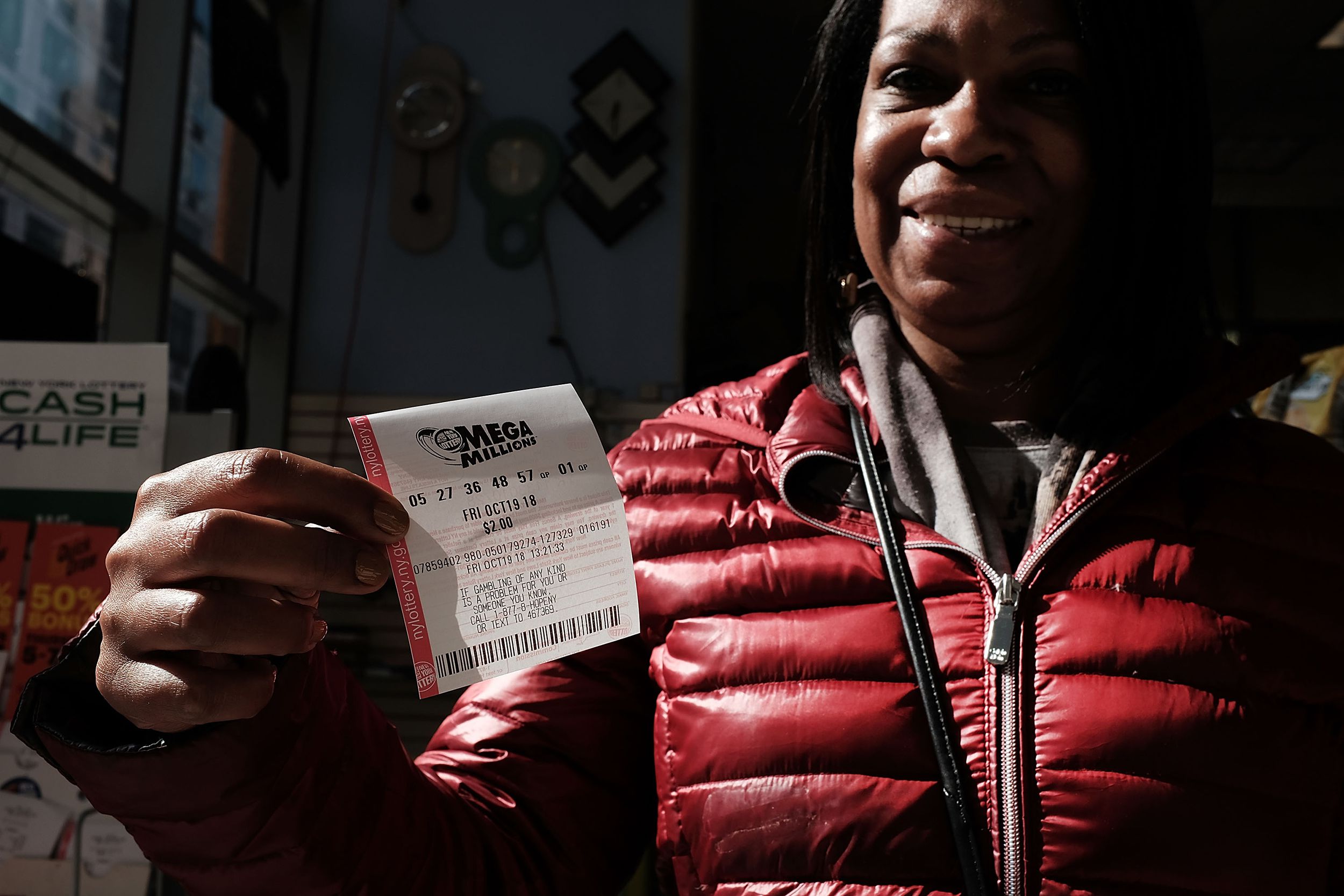 A woman holds up her Mega Millions lottery ticket at a Brooklyn store on October 19, 2018 in the Brooklyn borough of New York City.