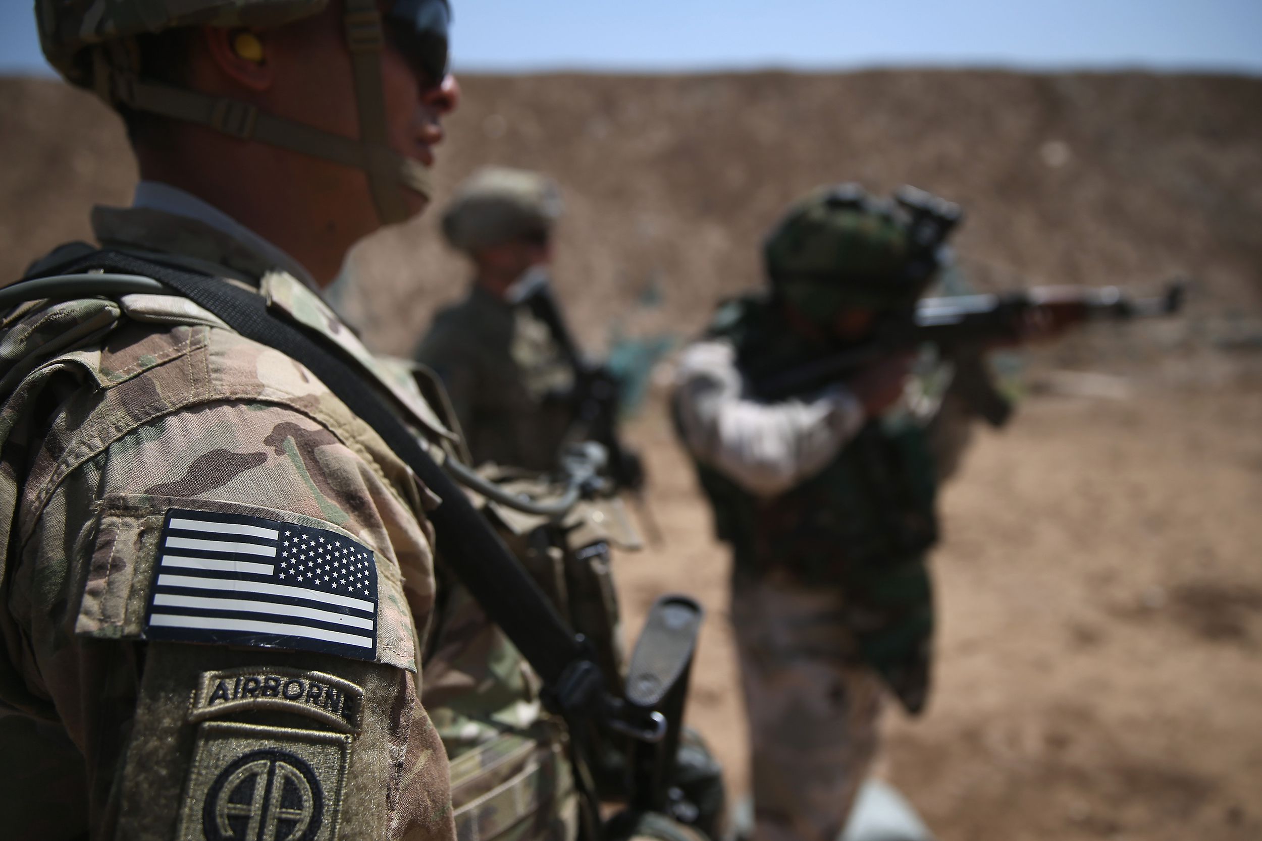 U.S. Army trainers watch as an Iraqi recruit fires at a military base on April 12, 2015 in Taji, Iraq.