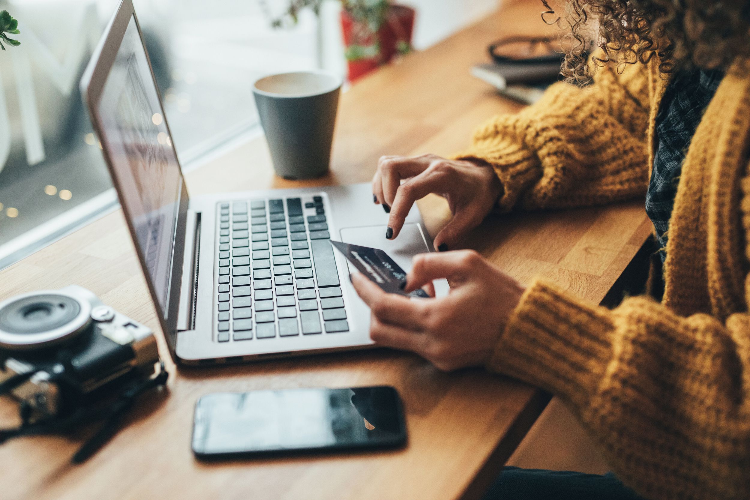woman at coffee shop shopping on laptop