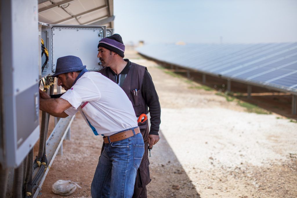 two people examining power system at Azraq, the world’s first refugee camp powered by renewable energy, funded by the IKEA Foundation