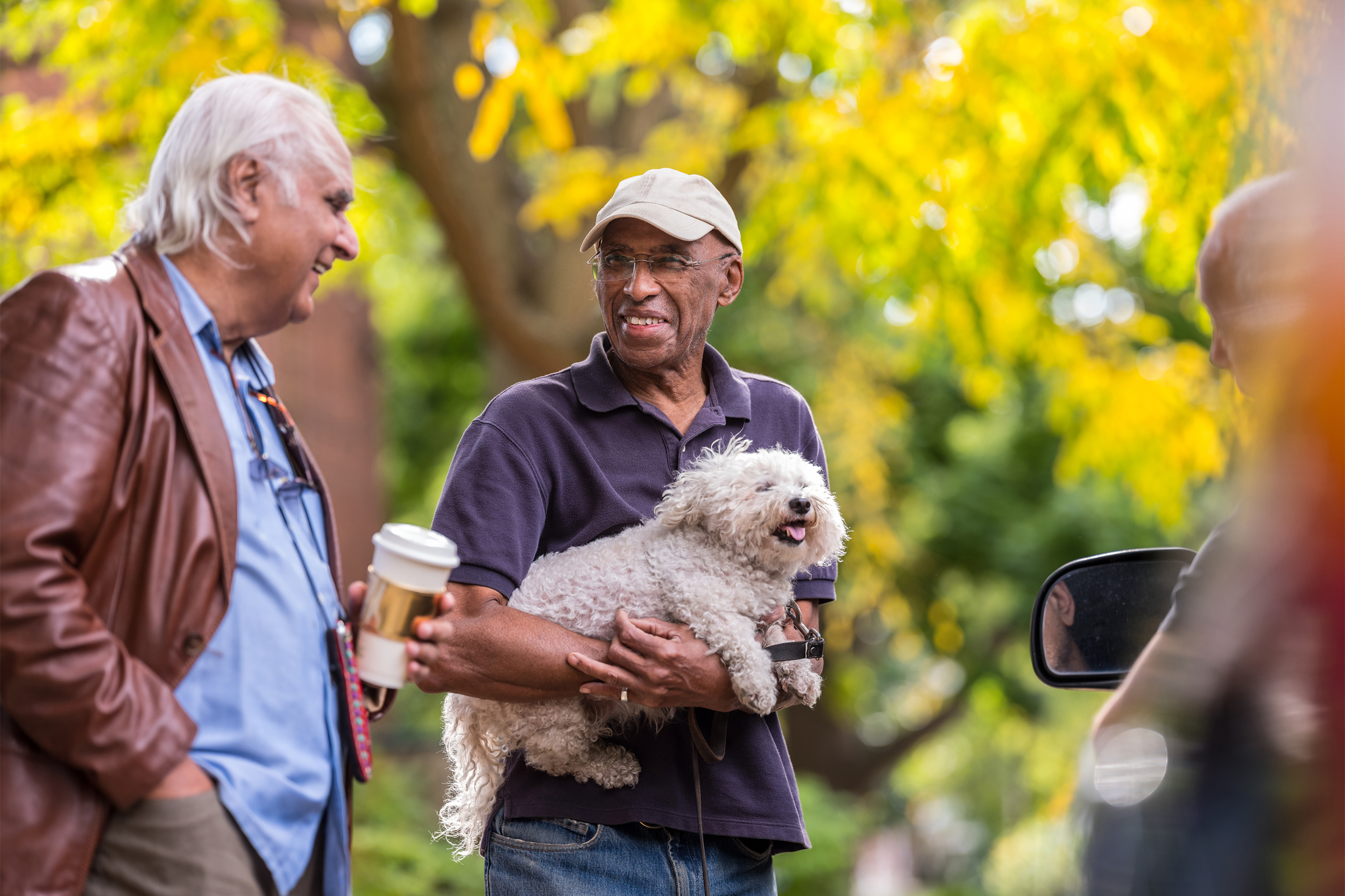 Neighbors talking while holding a dog