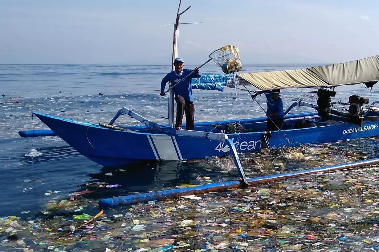 4ocean cleanup crew member in boat cleaning plastics from ocean