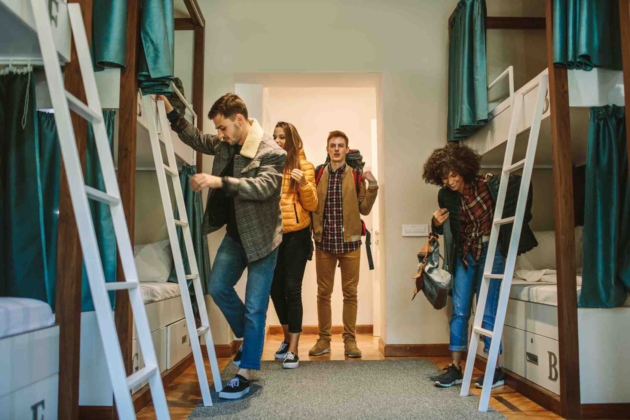 group of young people entering hostel shared room