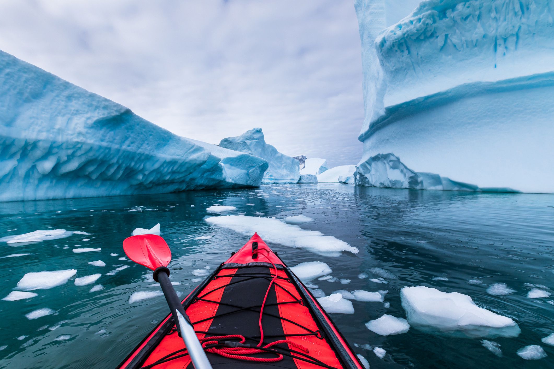 kayaking in antarctica between icebergs with inflatable kayak, extreme adventure in antarctic peninsula